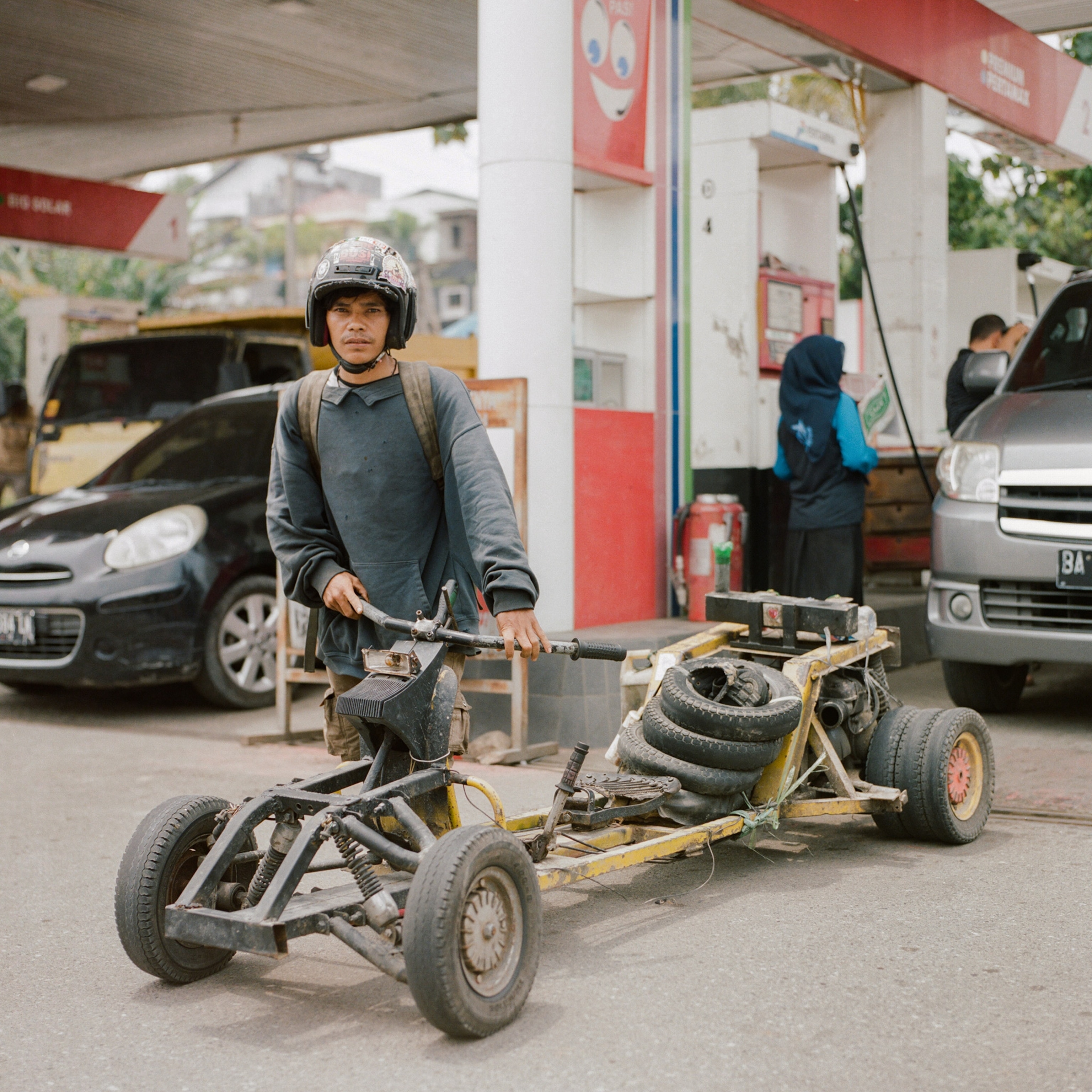 a person with a vespa at a petrol station in Indonesia