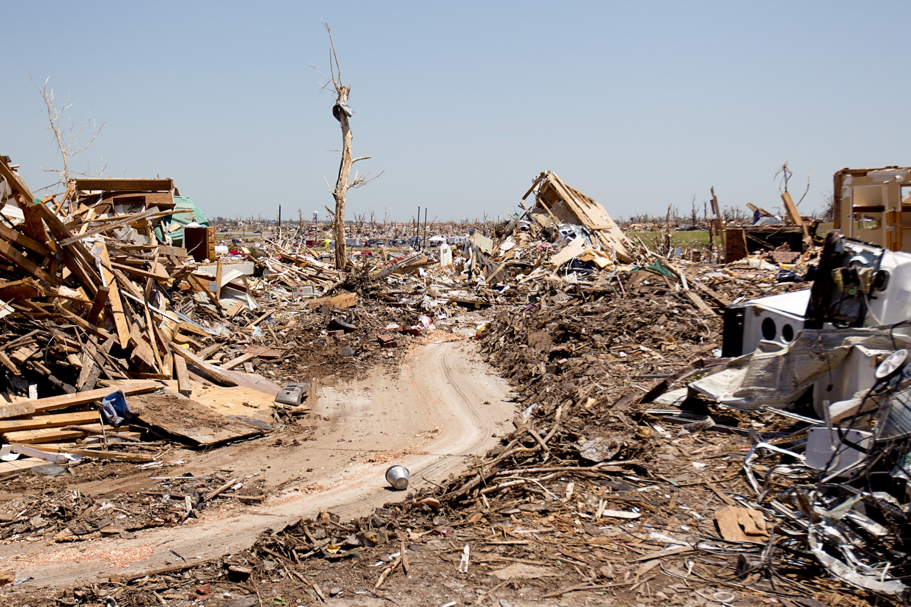A road that winds into hills of debris and wreckage following a tornado