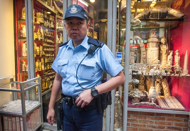A police officer stands guard outside an ivory shop during a protest in Hong Kong. Amid growing pressure after China announced on September 25 that it will ban the ivory trade, Hong Kong said it is now “open-minded” to a ban on its legal ivory trade. Photograph by Alex Hofford, EPA