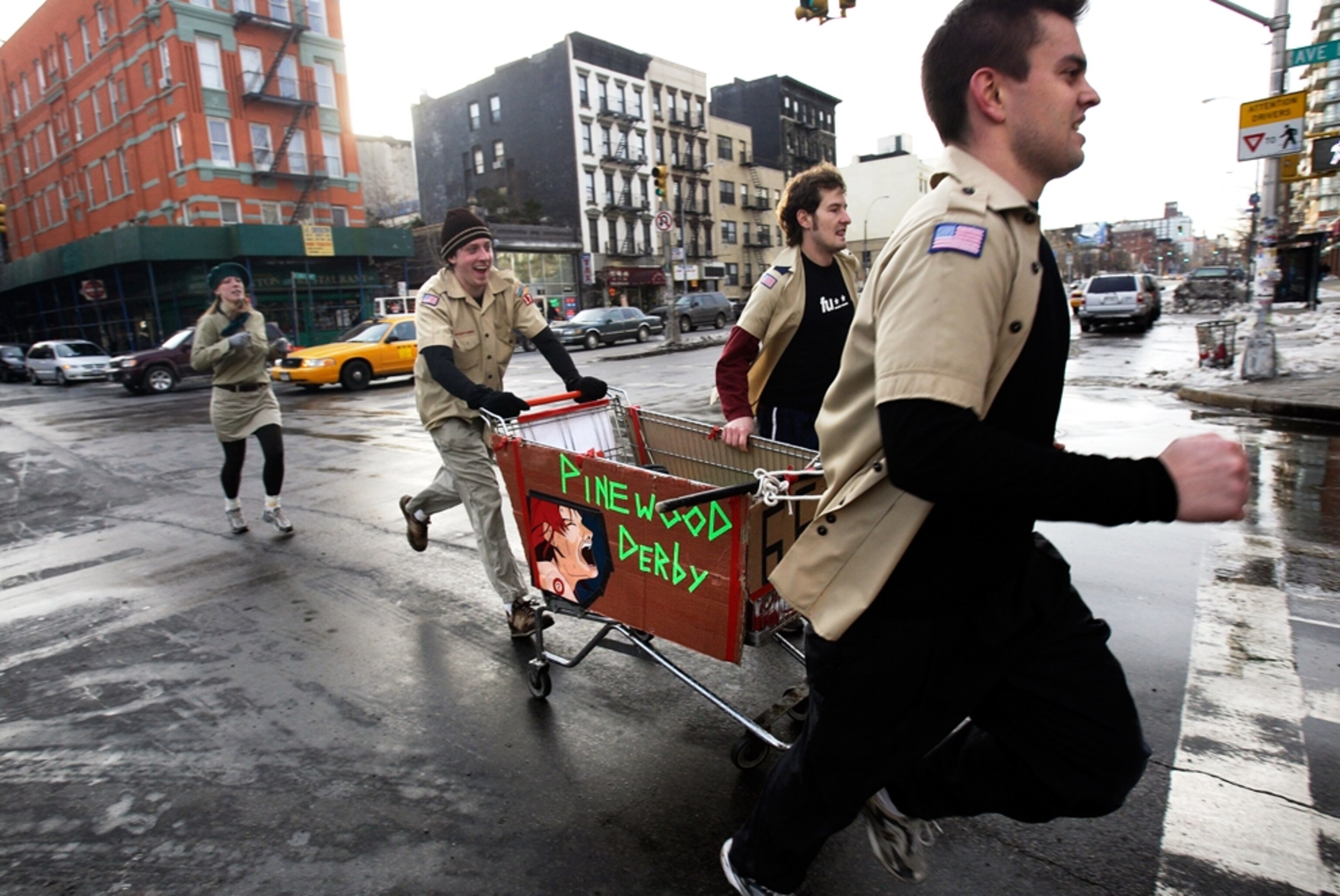 team dressed as Boy Scouts racing with shopping cart