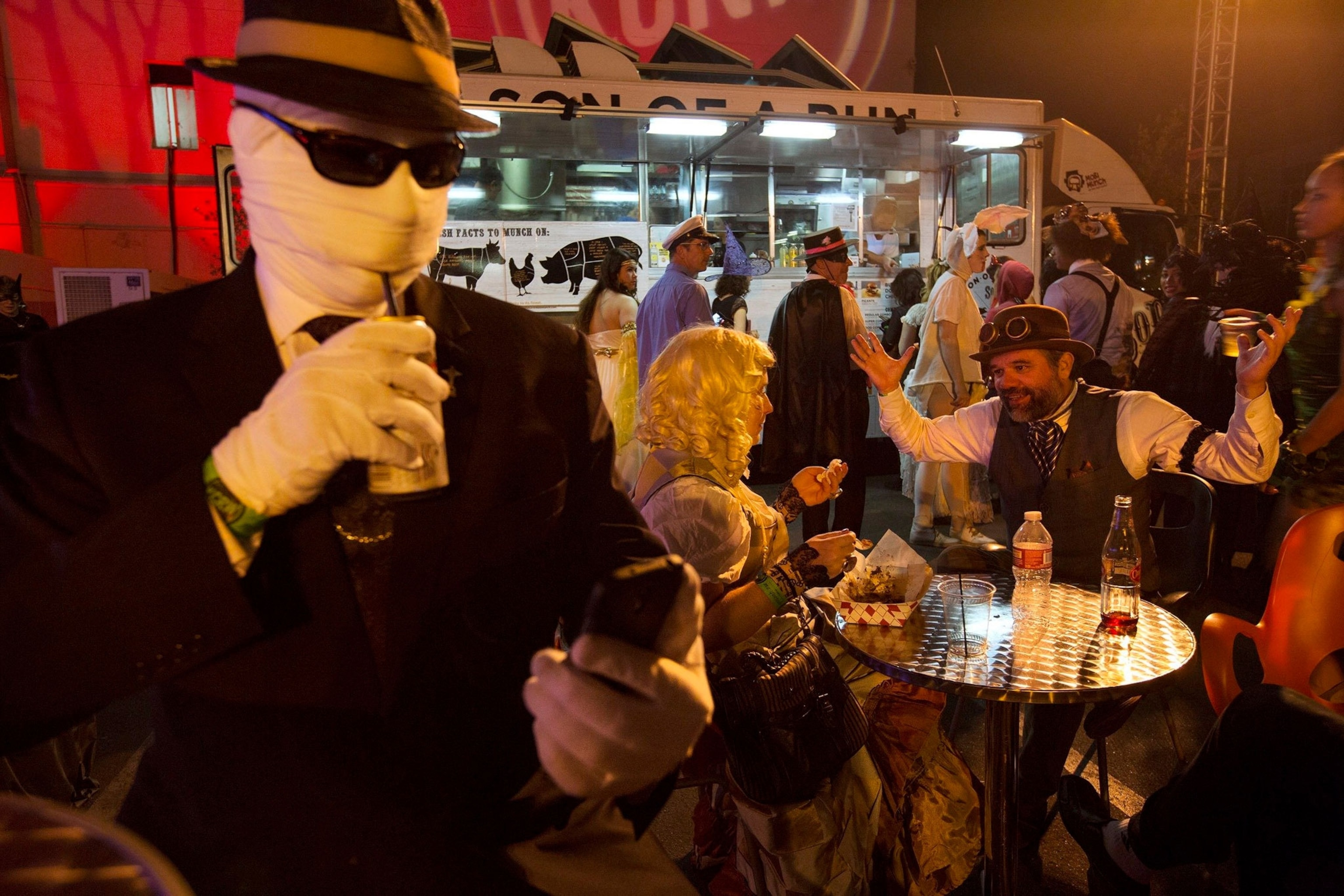 People dressed in Halloween costumes eat at food truck in LA