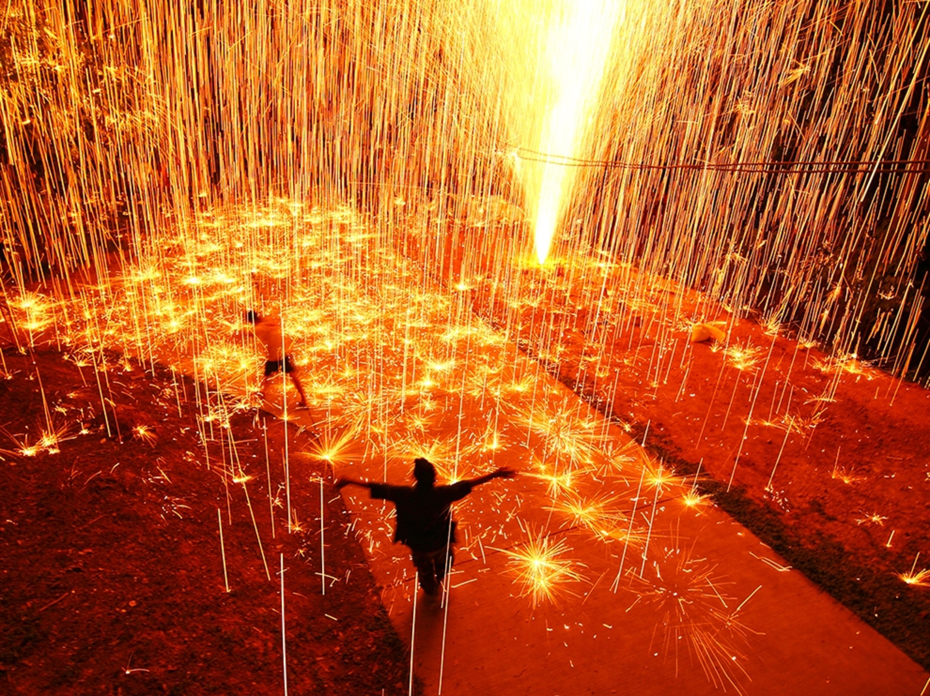 people dancing in a shower of fireworks in Thailand.