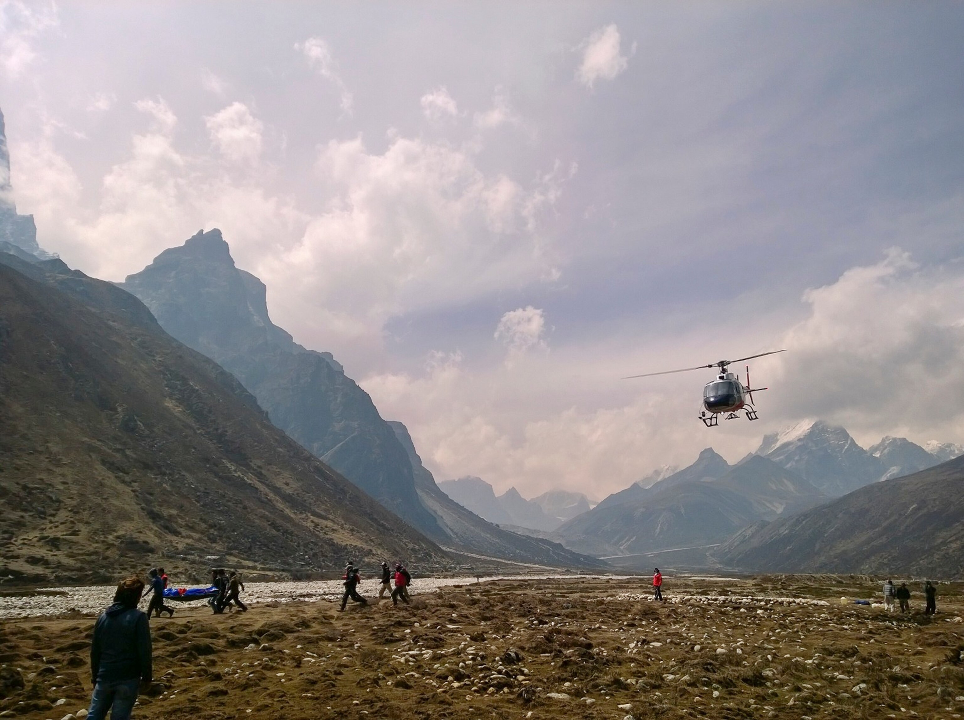 an expedition member standing in front of the Himalayan range.