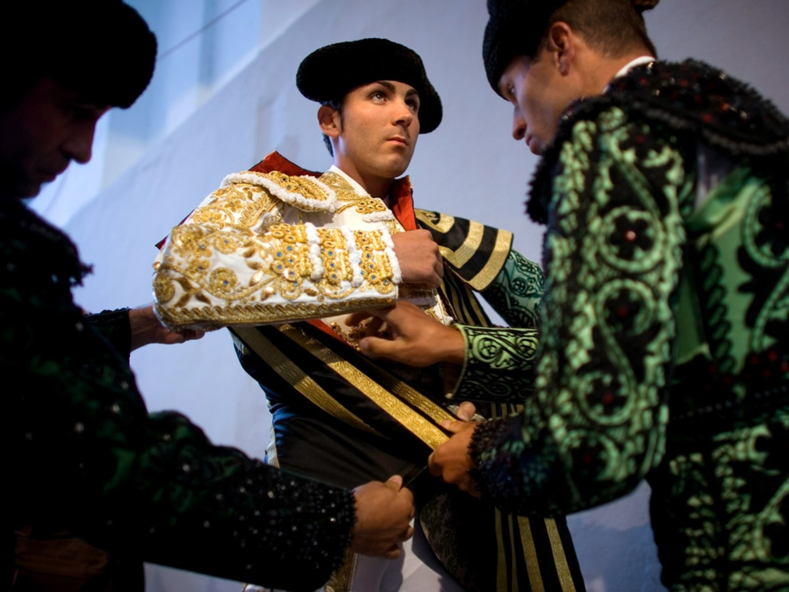 Men adjusting a matador’s costume