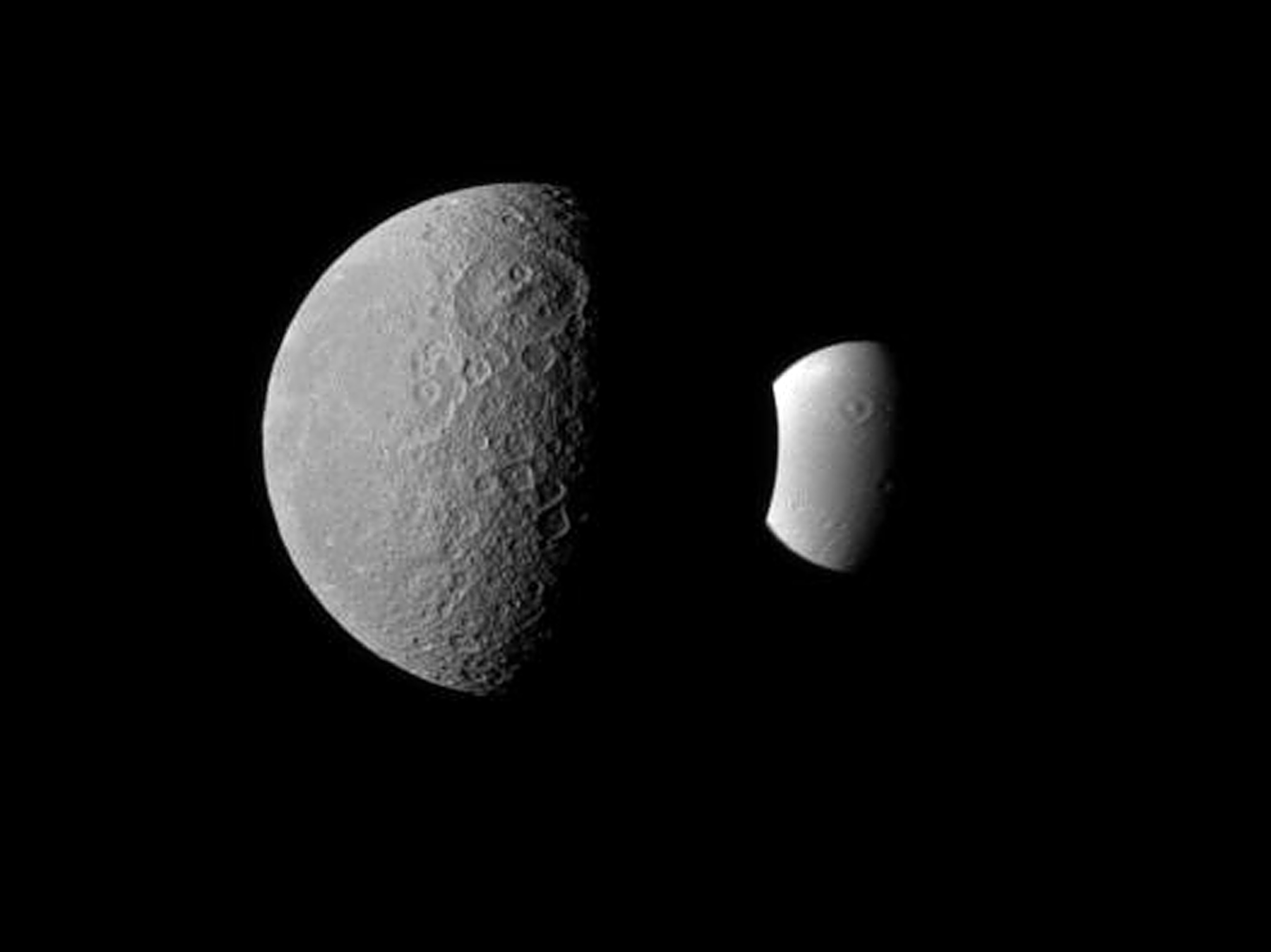 two Saturn moons with similar looking craters