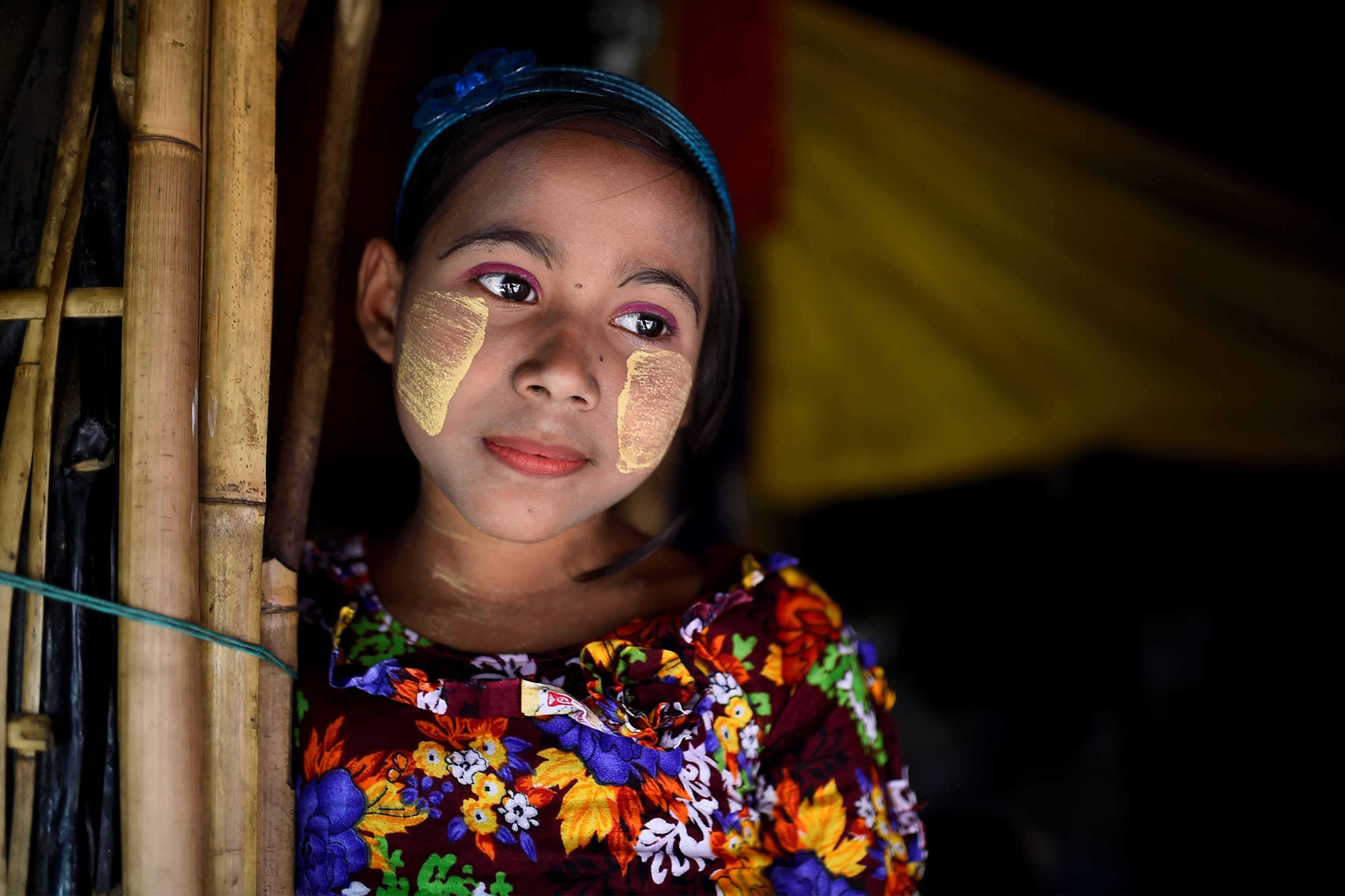 a Rohingya girl wearing paint on her face to protect her from the sun
