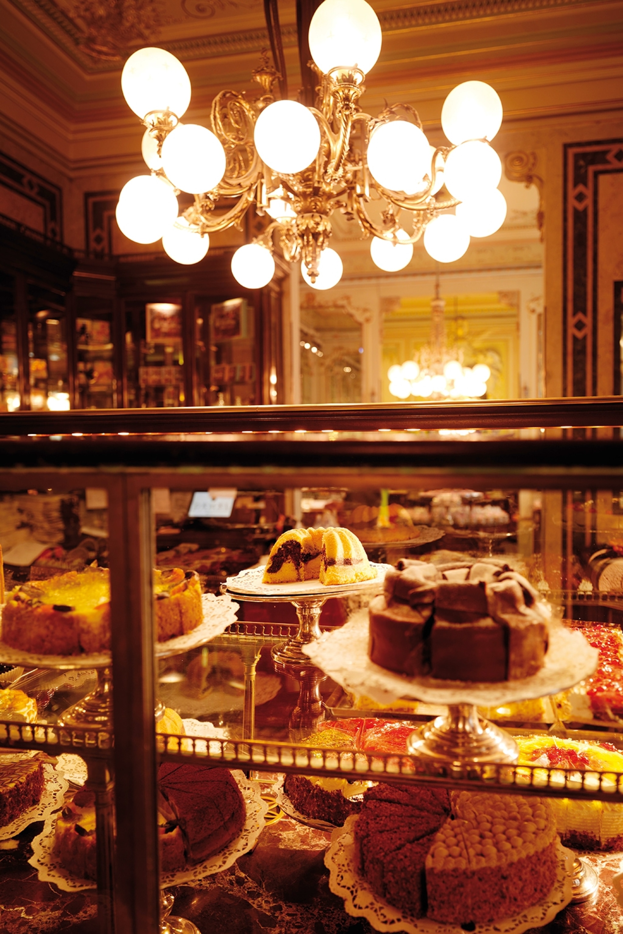 A warmly-lit cake display in a cafe.