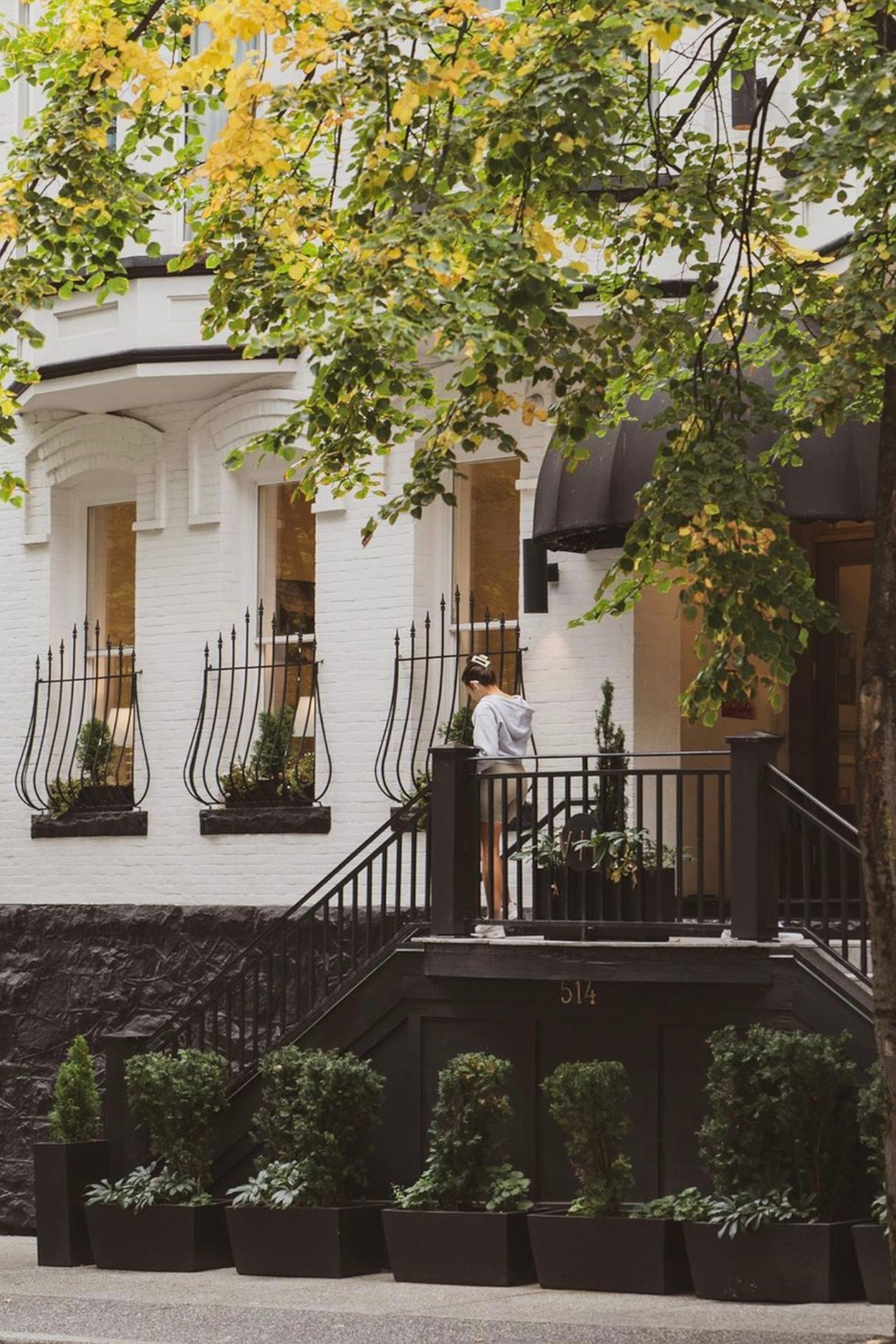 The exteriors of a Victorian hotel with steps leading down to the street level from its entrance.