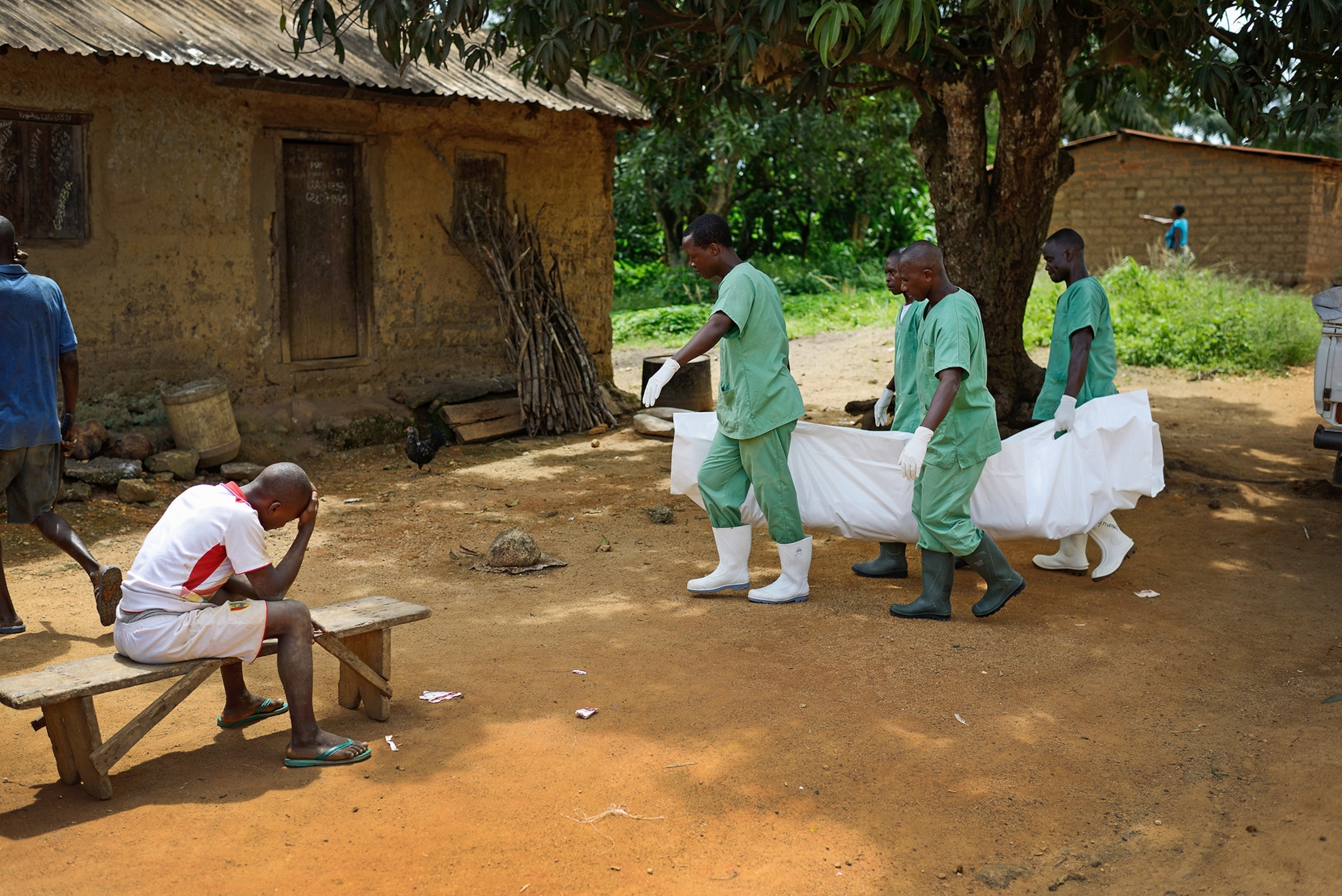 members from the Red Cross moving the body of an ebola victim.