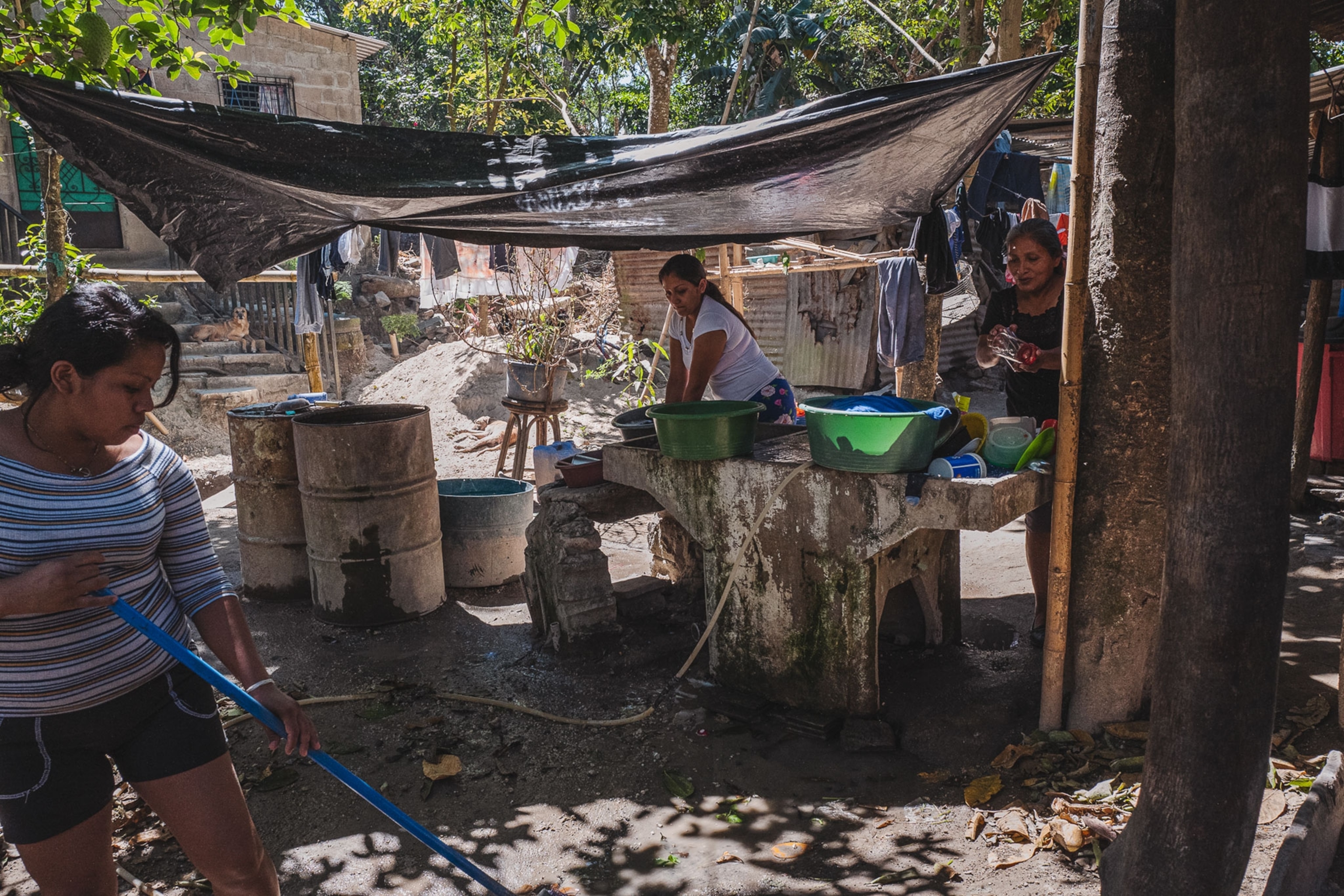 women wash clothes and do chores at their house in El Salvador