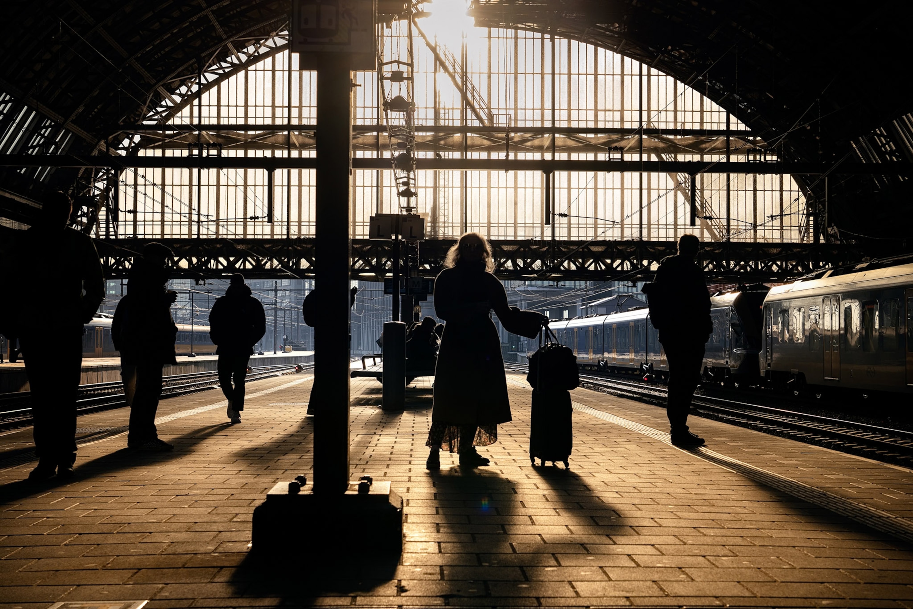 Multiple people standing on a train platform.
