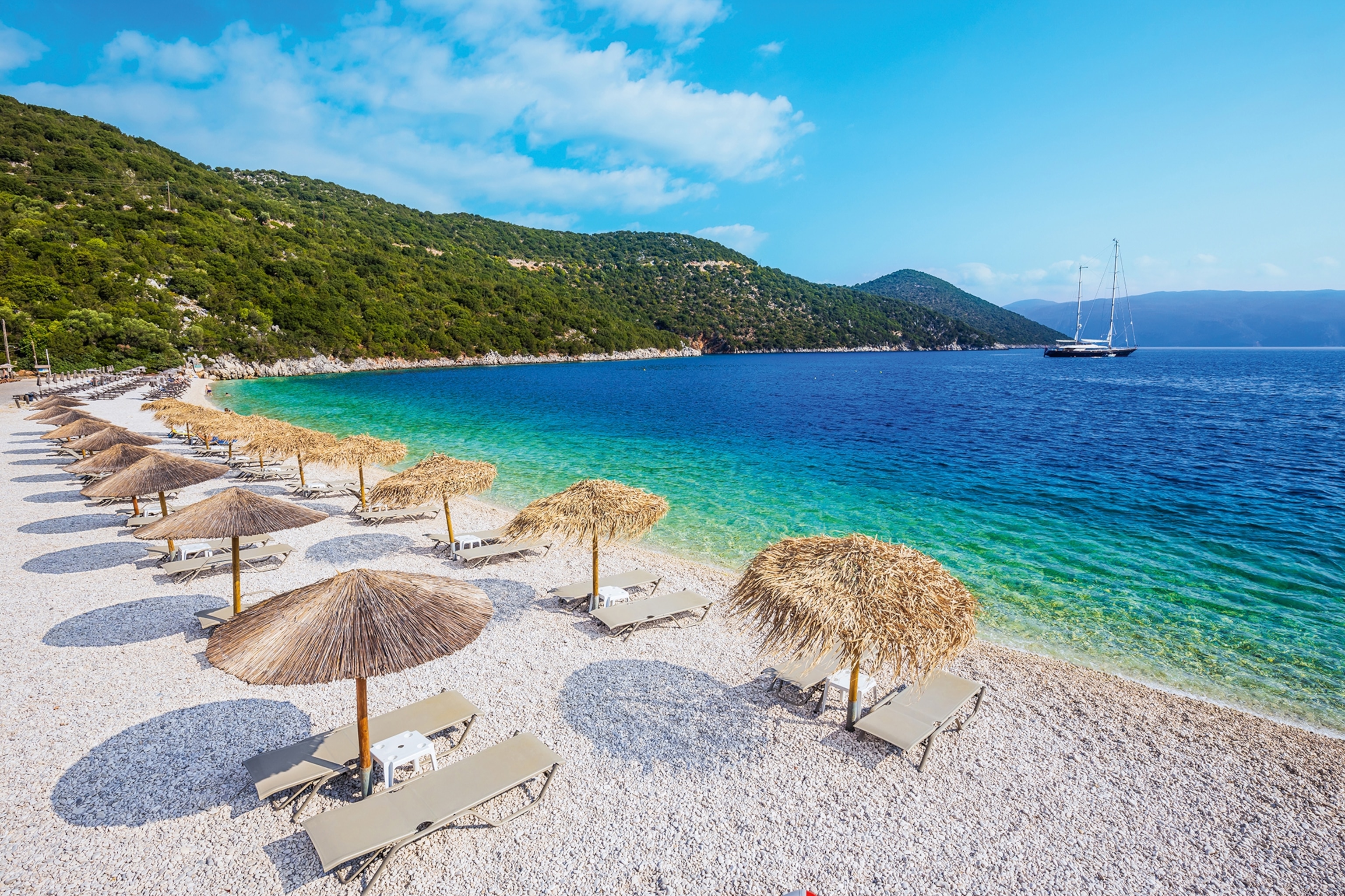A picture-perfect beach with parasols and a clear ocean.