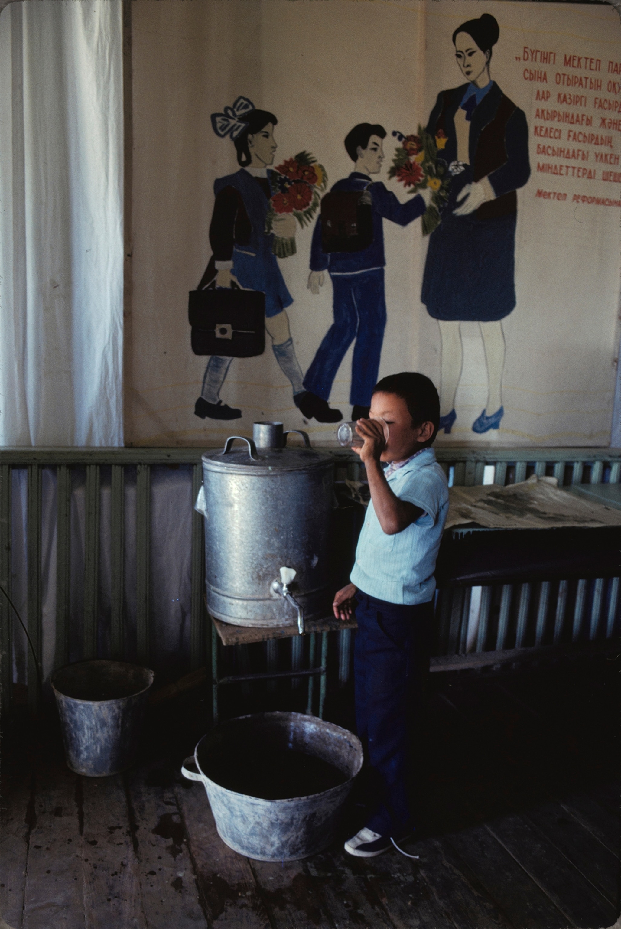 A schoolchild in the Muynak district drinks water from a container of potable water.