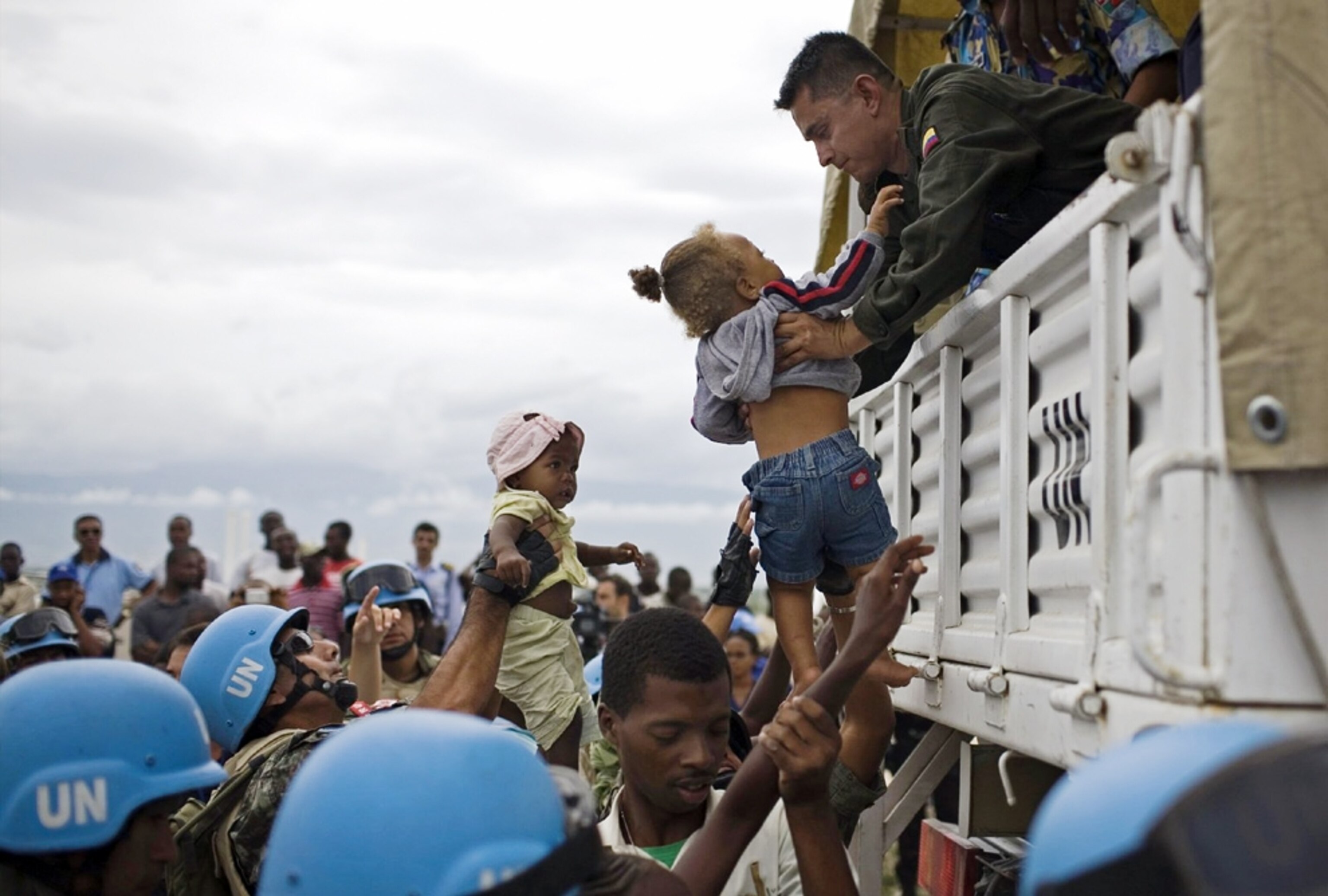 UN soldiers lift Haitian children into their truck -- picture from a photo gallery on the one-year Haiti-earthquake anniversary
