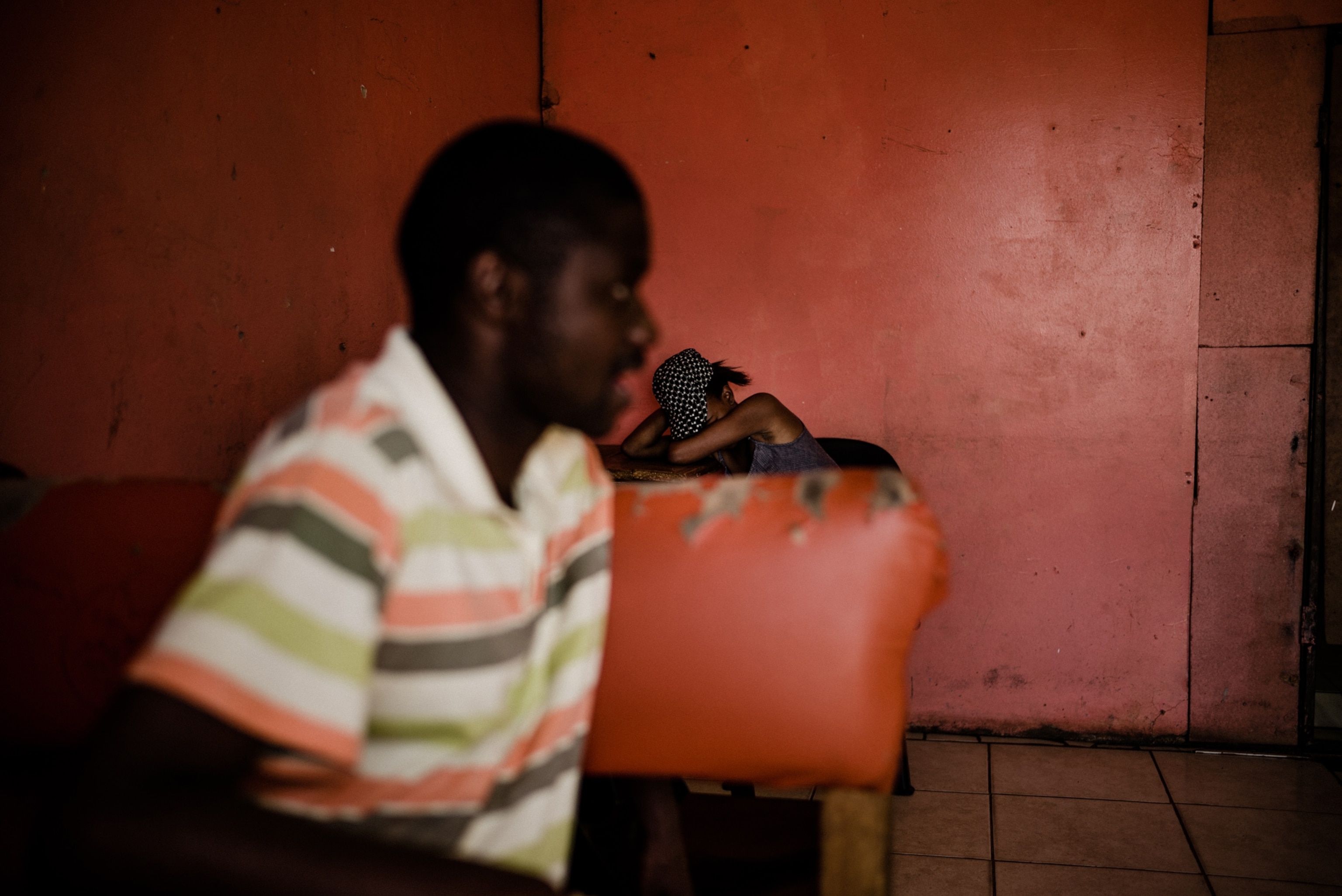 Two people sit in a red room in Johannesburg, South Africa.