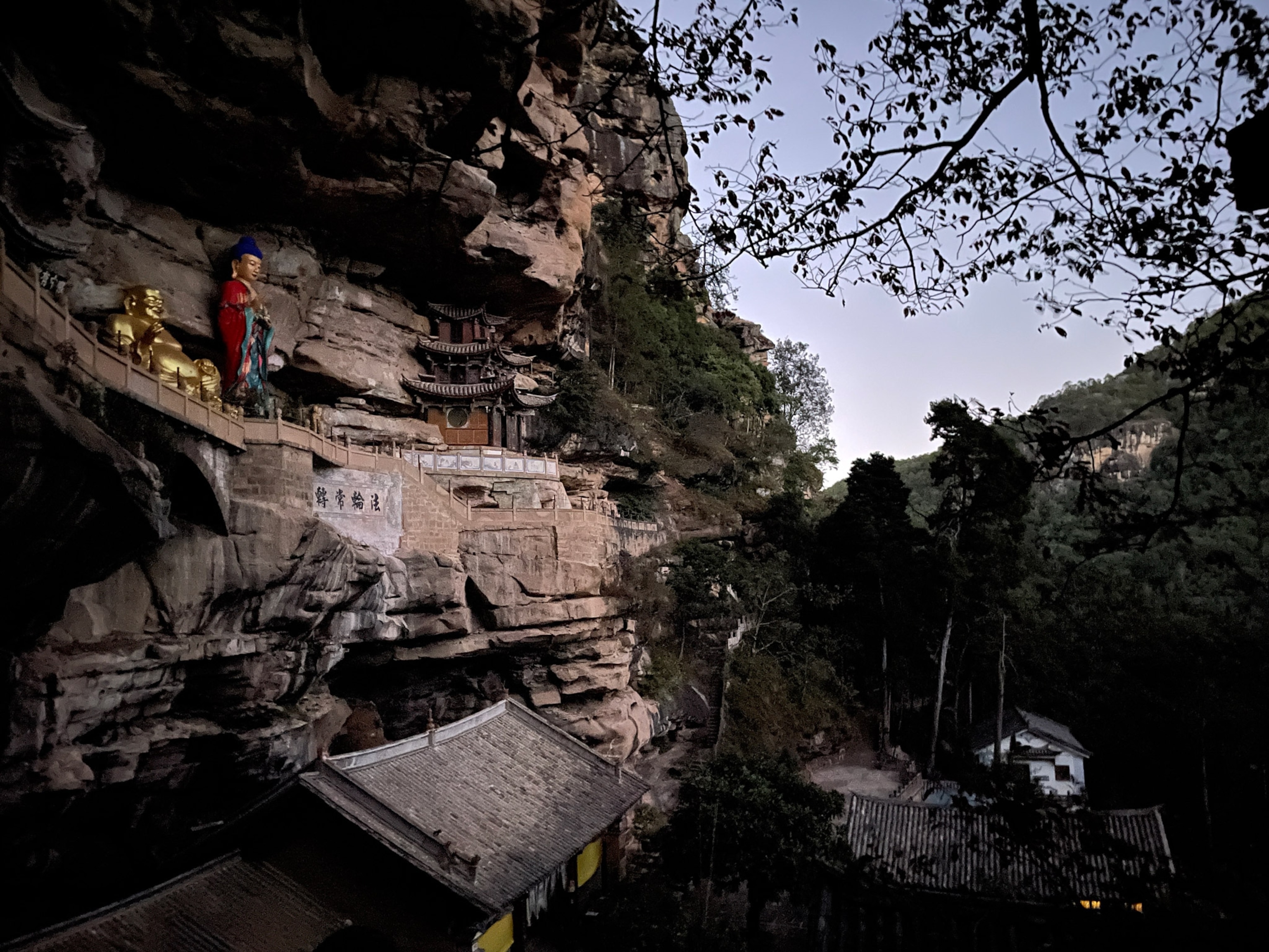 Photo of statues of Buddha in the walls of a rock
