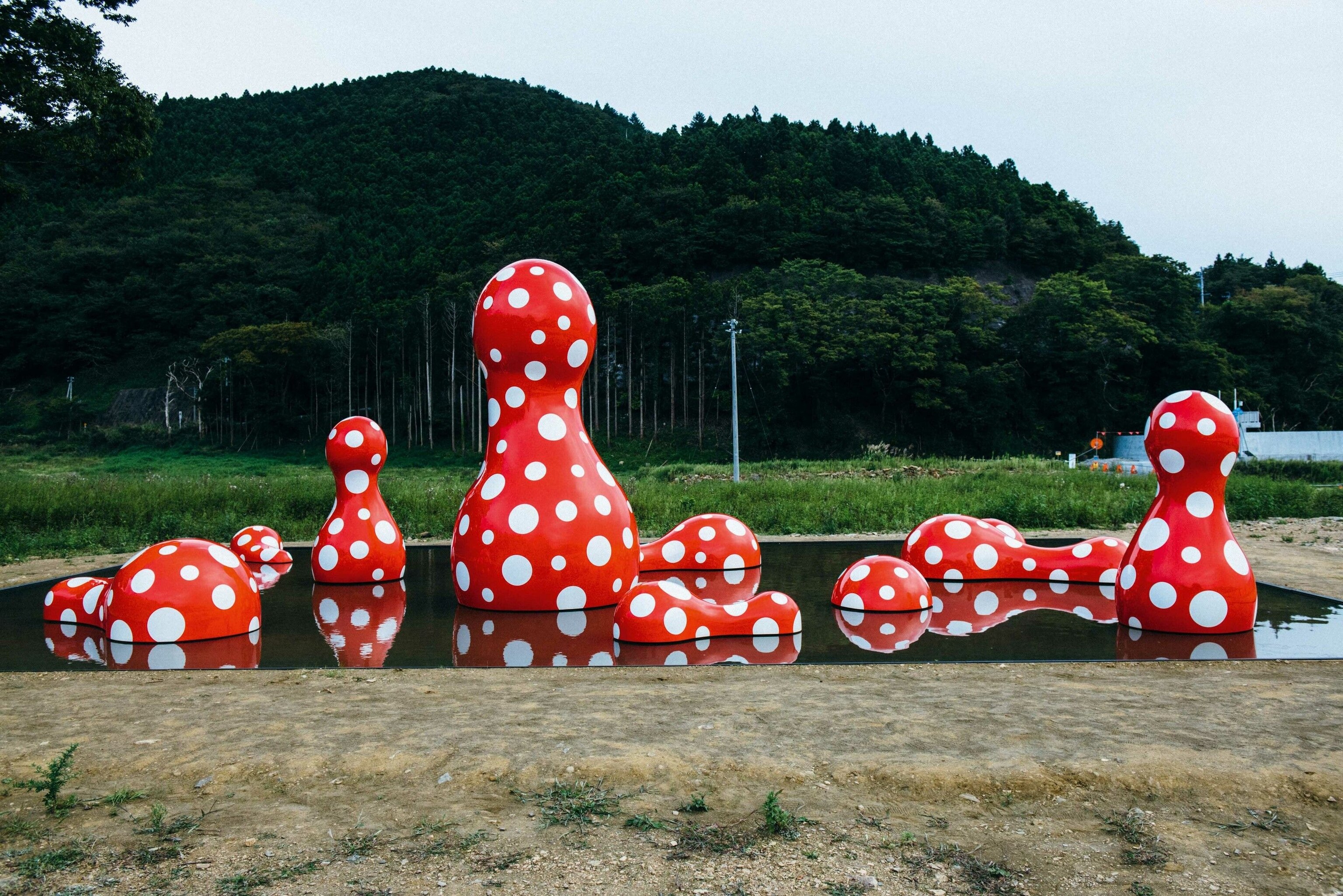 Red shapes with white spots. They are shaped like bowling pins or Russian dolls, and some of them lay flat on the floor, split in half vertically.