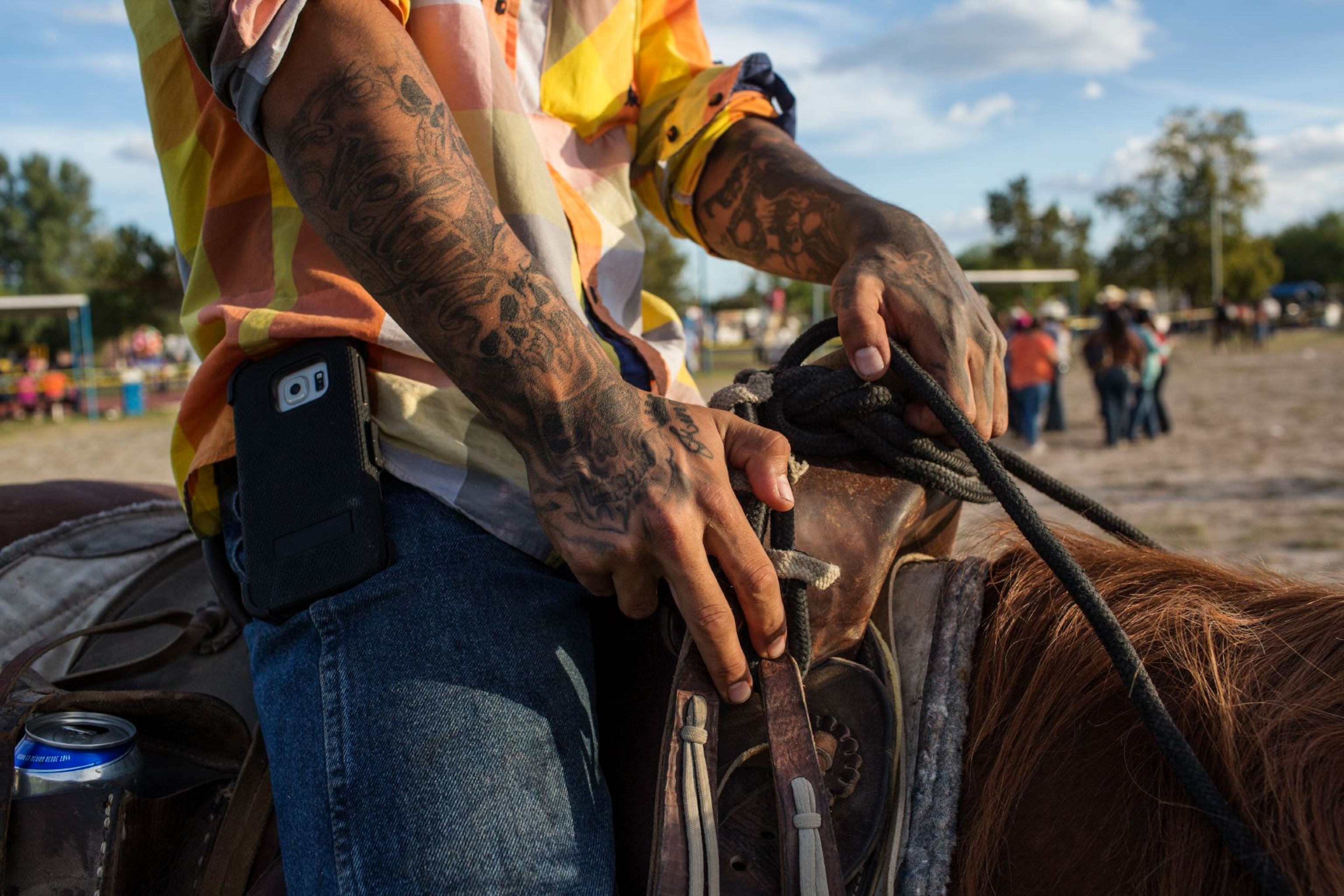 a boy with tattoos sitting atop a horse