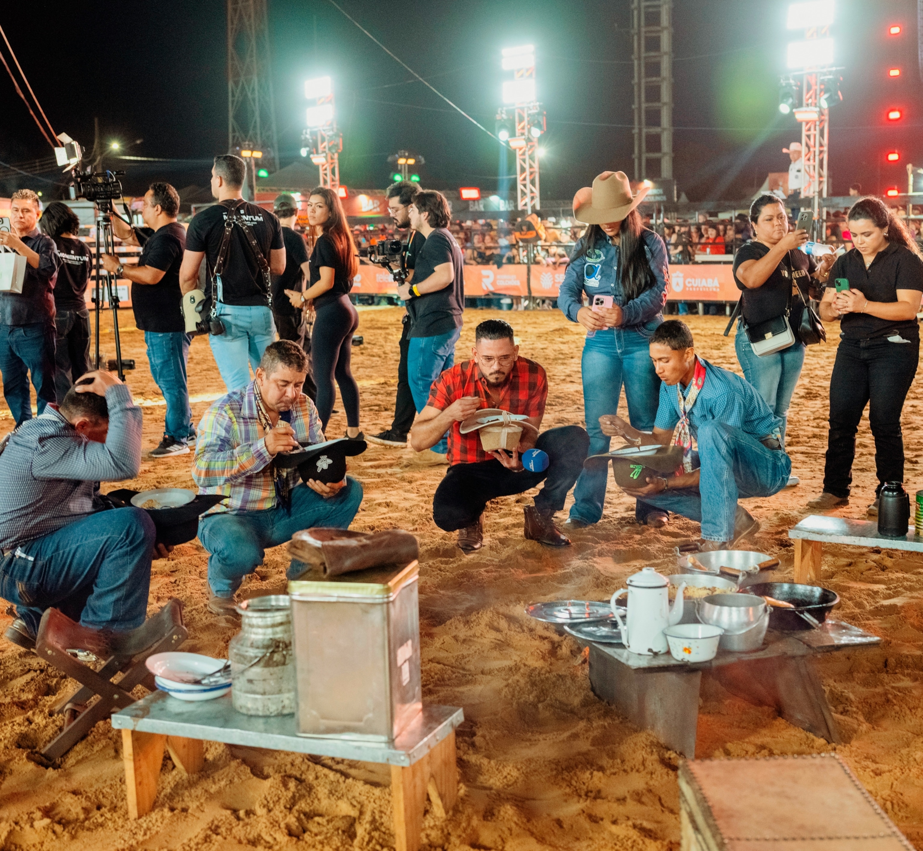 Rodeo riders squat down and eat from their hats (well, bowls held in their hats).