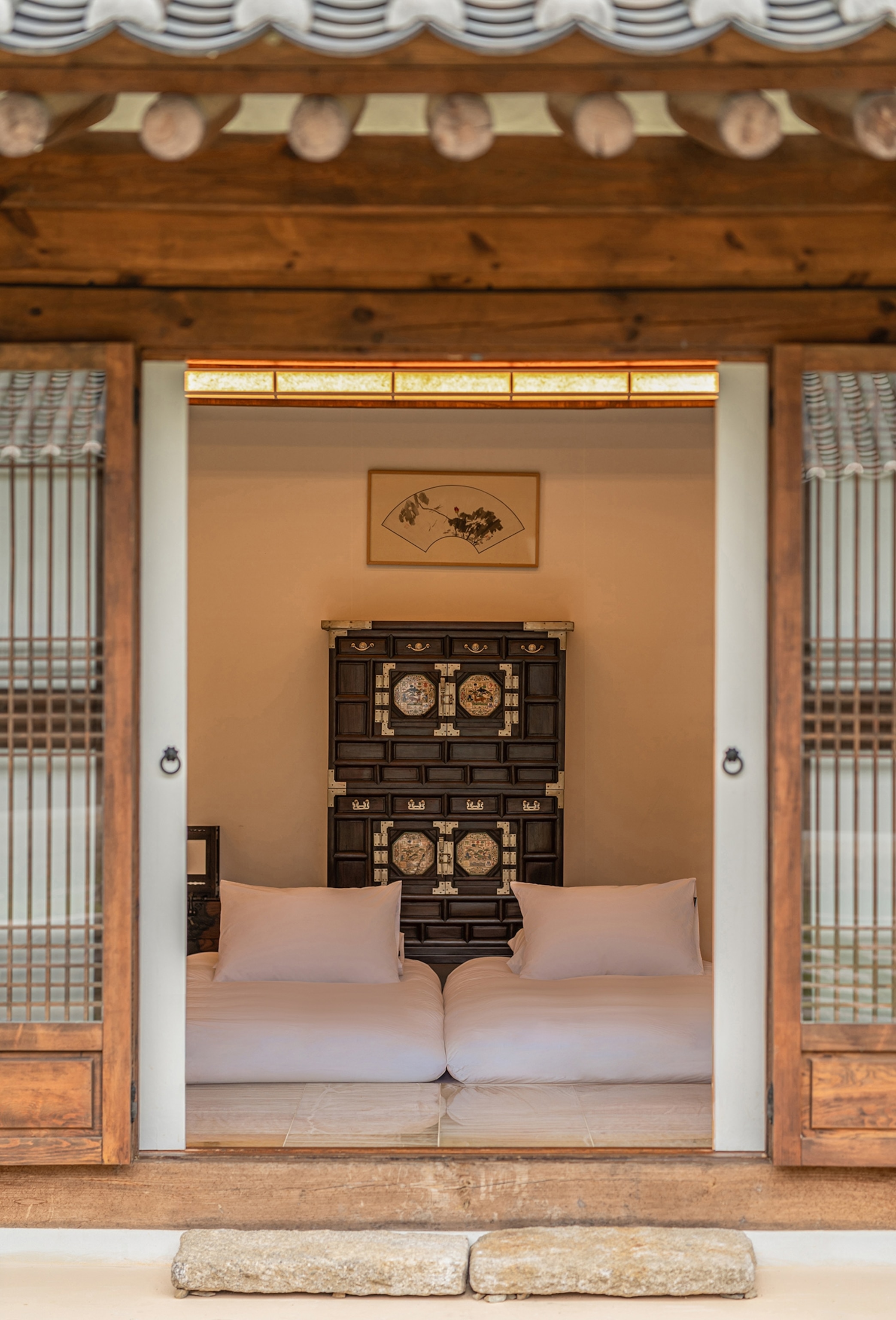 A serene guestroom at Rakkojae Andong Hahoe, where traditional Korean wooden furniture and floor bedding create an authentic hanok experience.