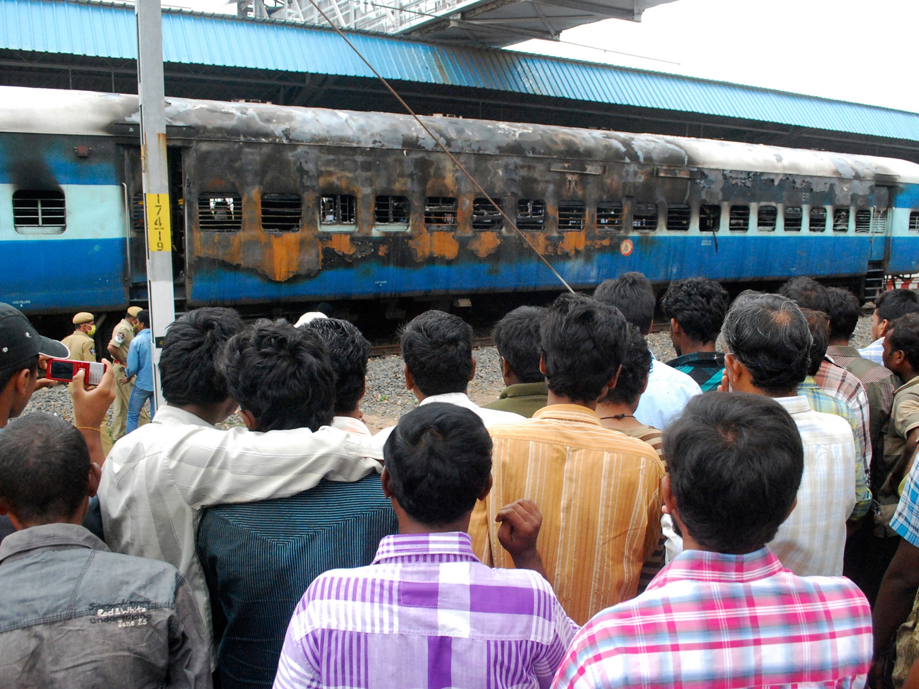 India power outage picture: crowd looks at a gutted train in Nellore during blackout