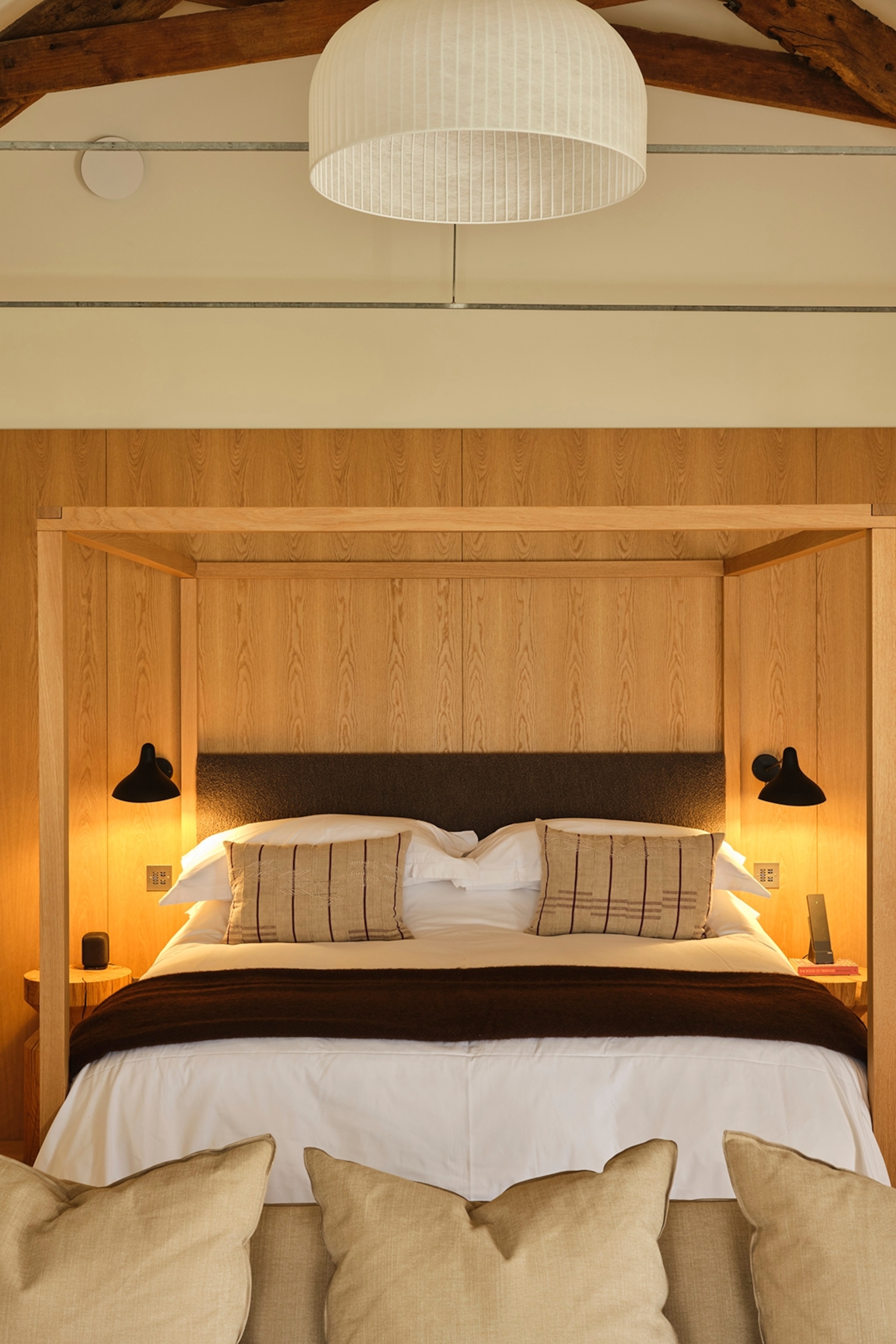 A wood-panelled hotel bedroom with warm and low lighting.