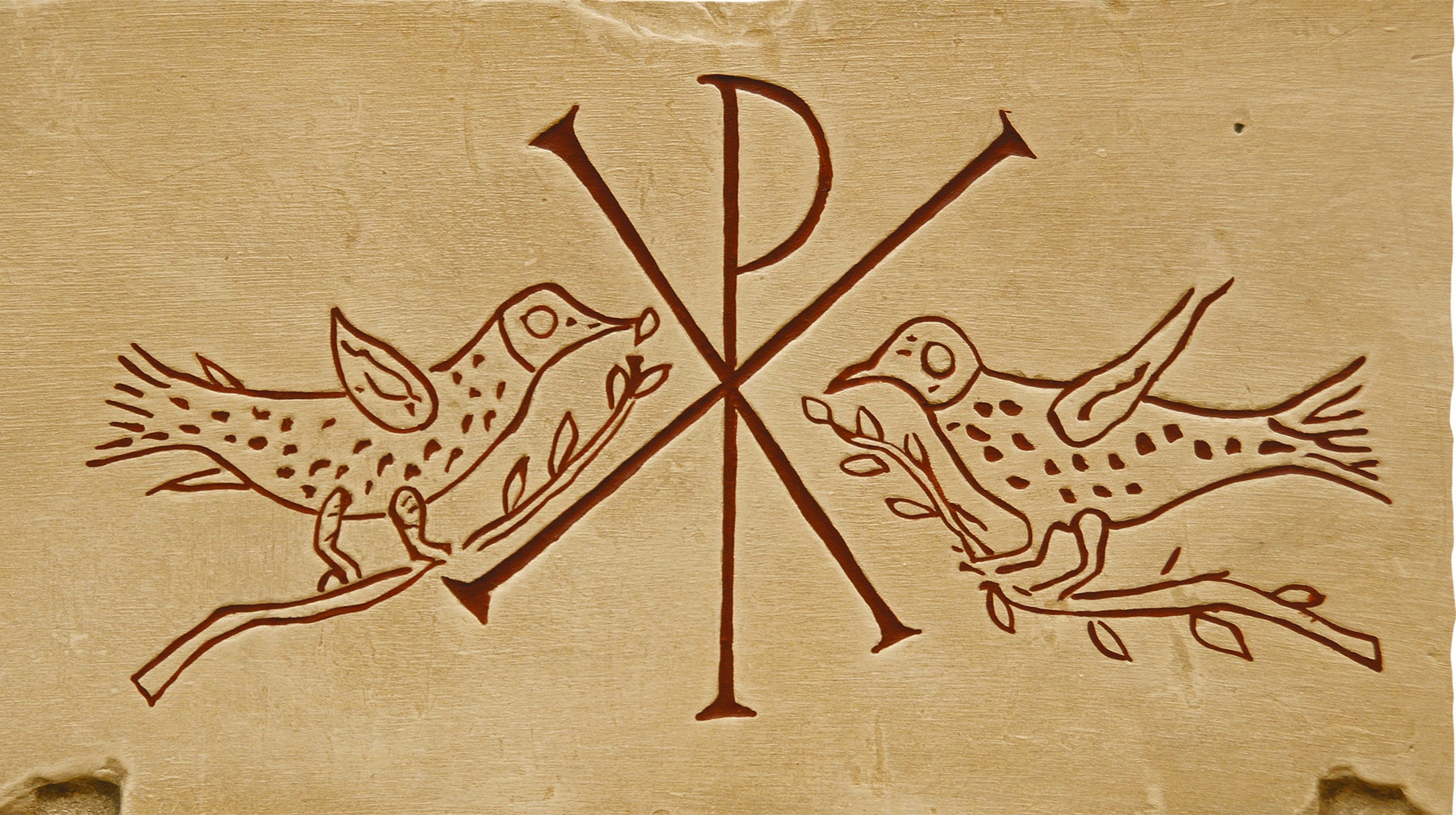 A relief of a Roman tombstone featuring the Christian Chi-Rho monogram, with two doves.
