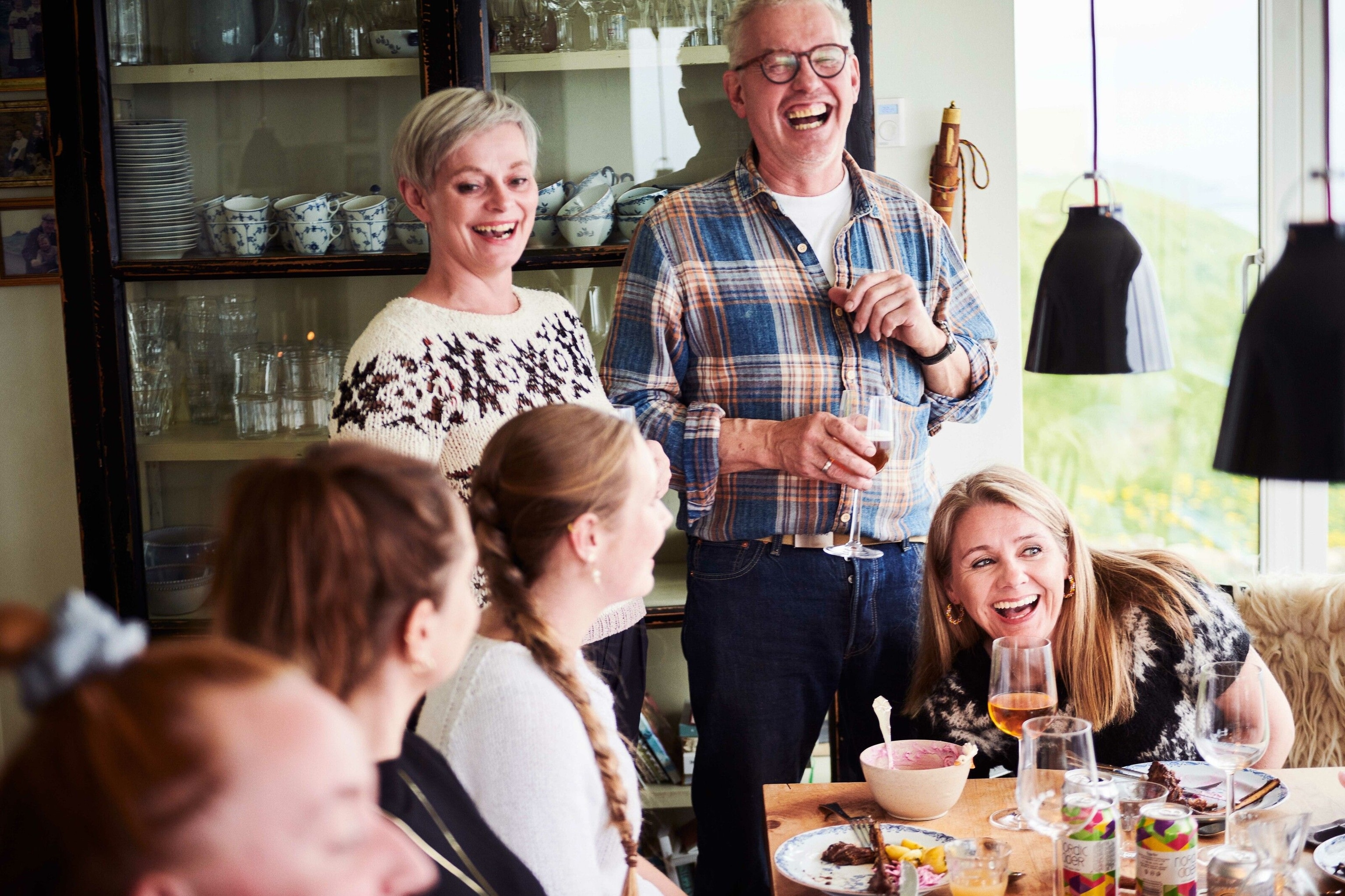 Anna and Óli take a break from cooking to share a toast with their dinner guests.