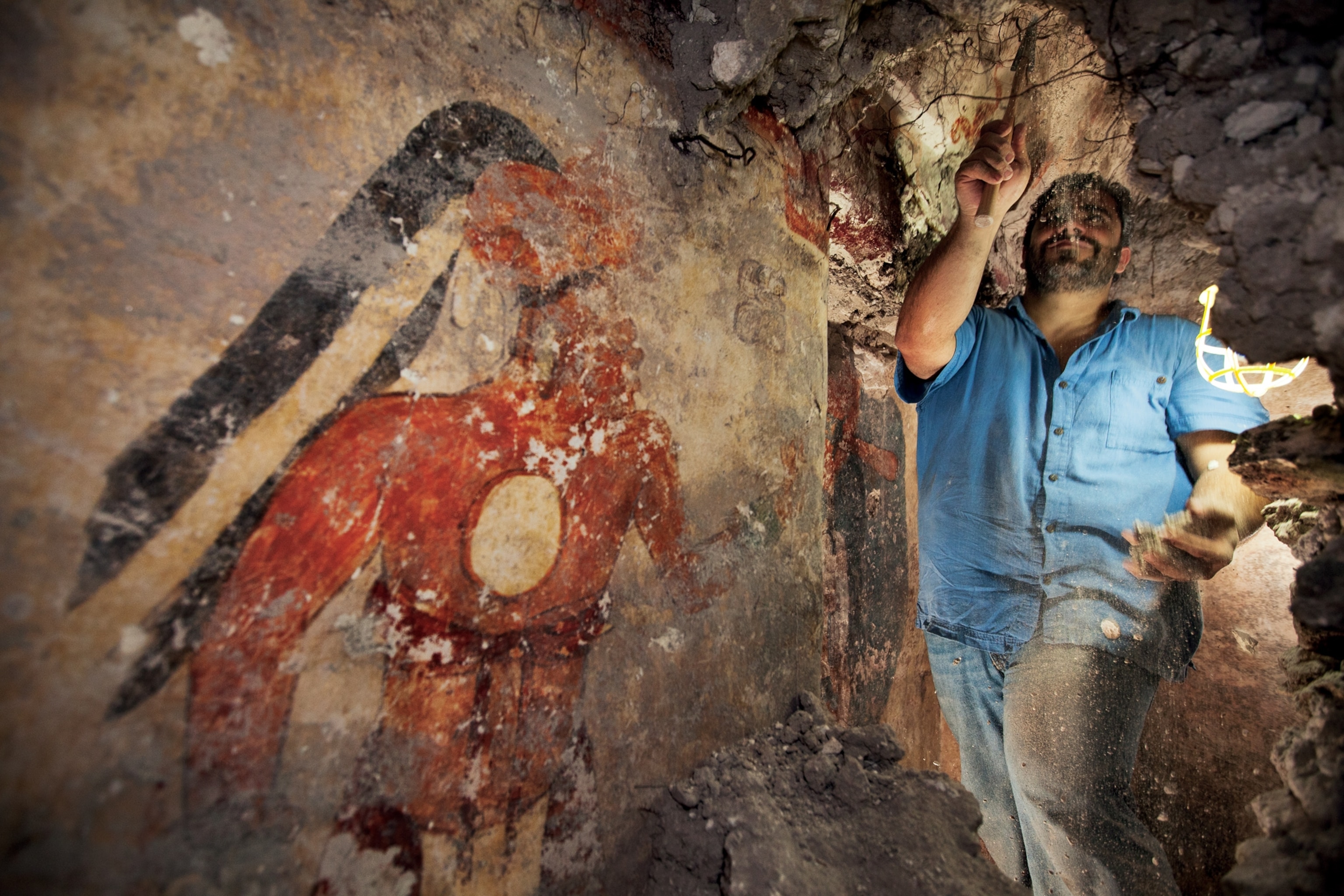 Maya house art picture: An archaeologist cleans debris inside a Maya home