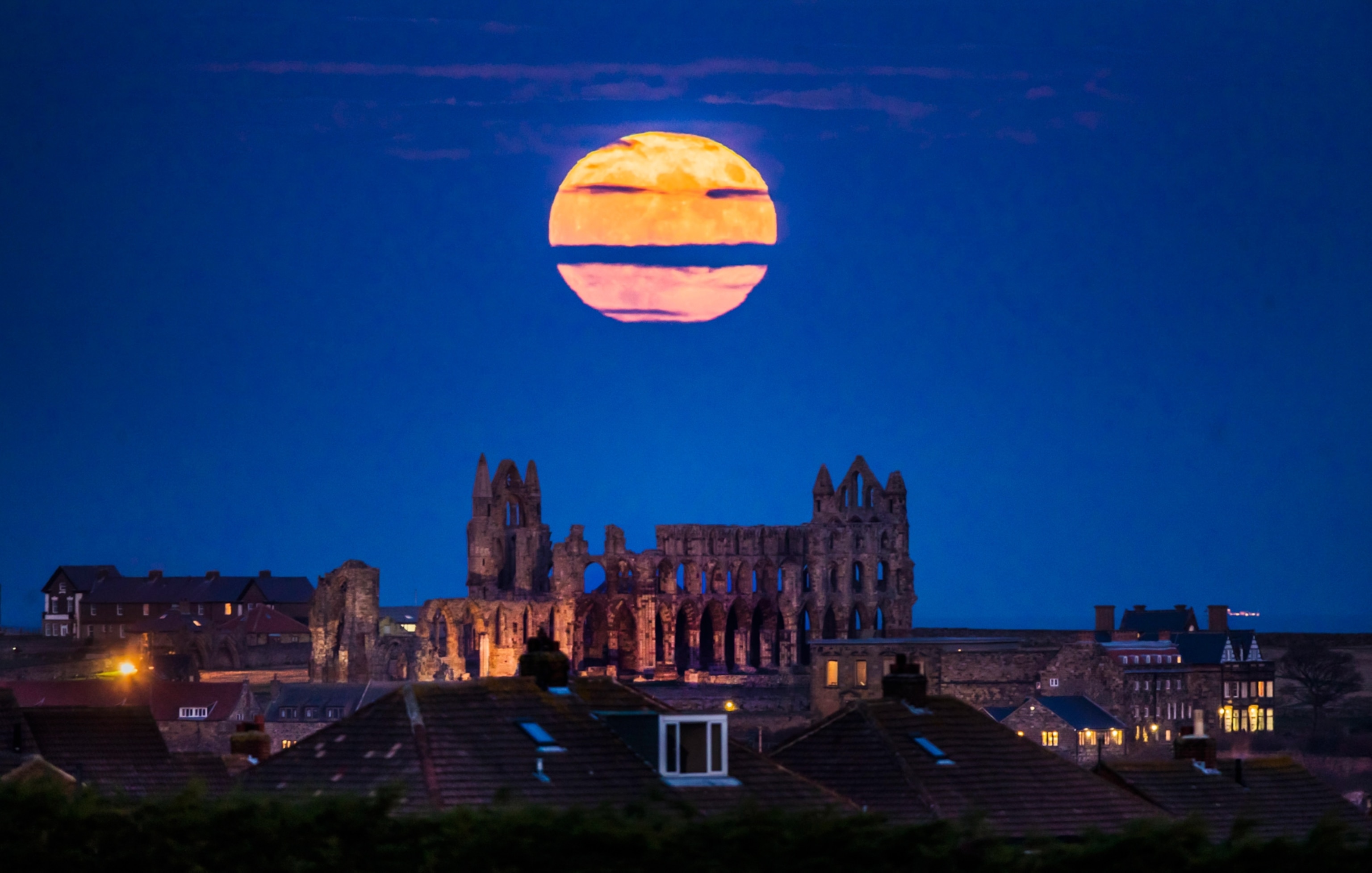 A full moon rising over Whitby Abbey in Yorkshire