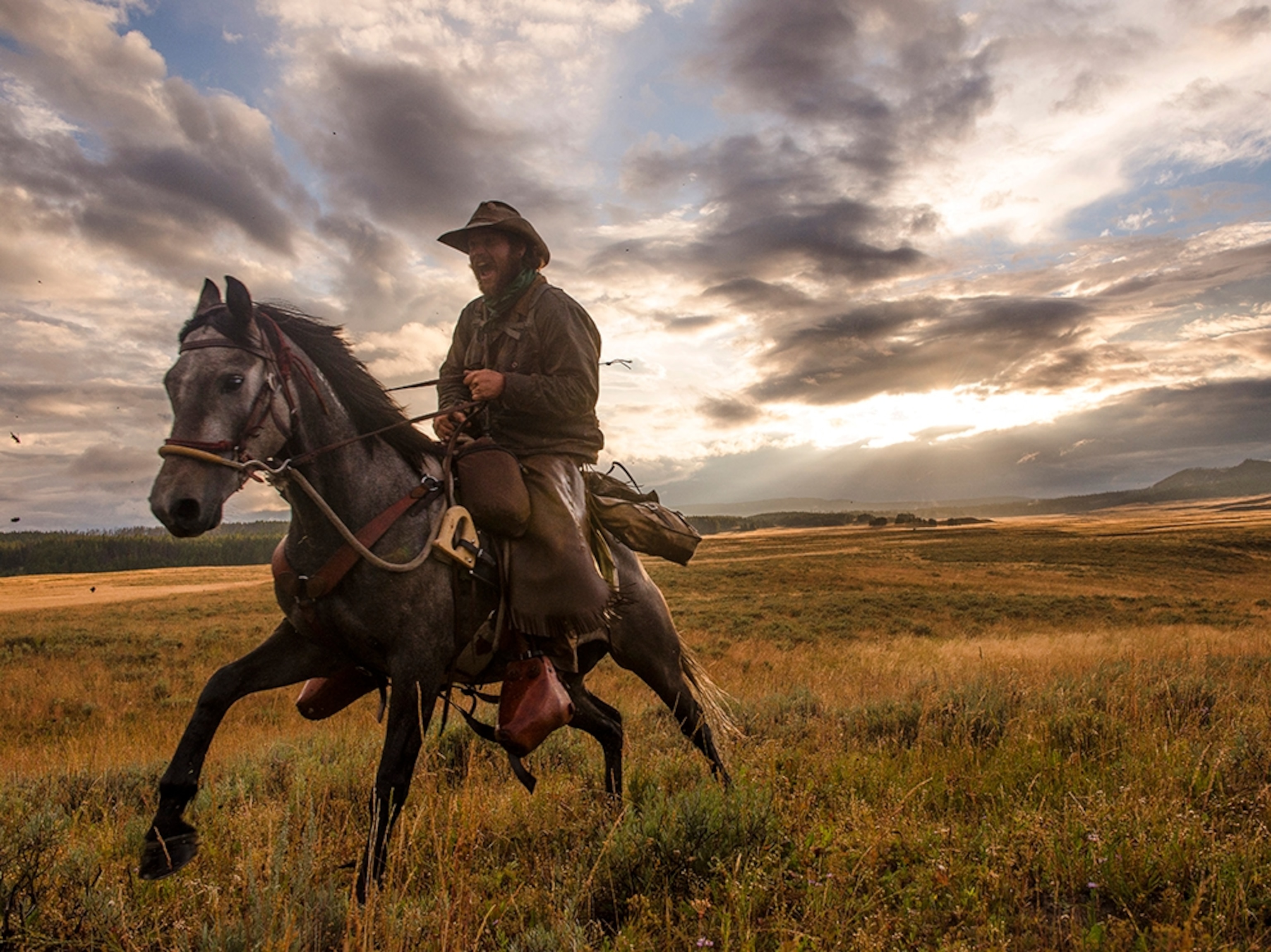 army veteran Ray Knell galloping through Pelican Valley as the sun sets over Yellowstone National Park.