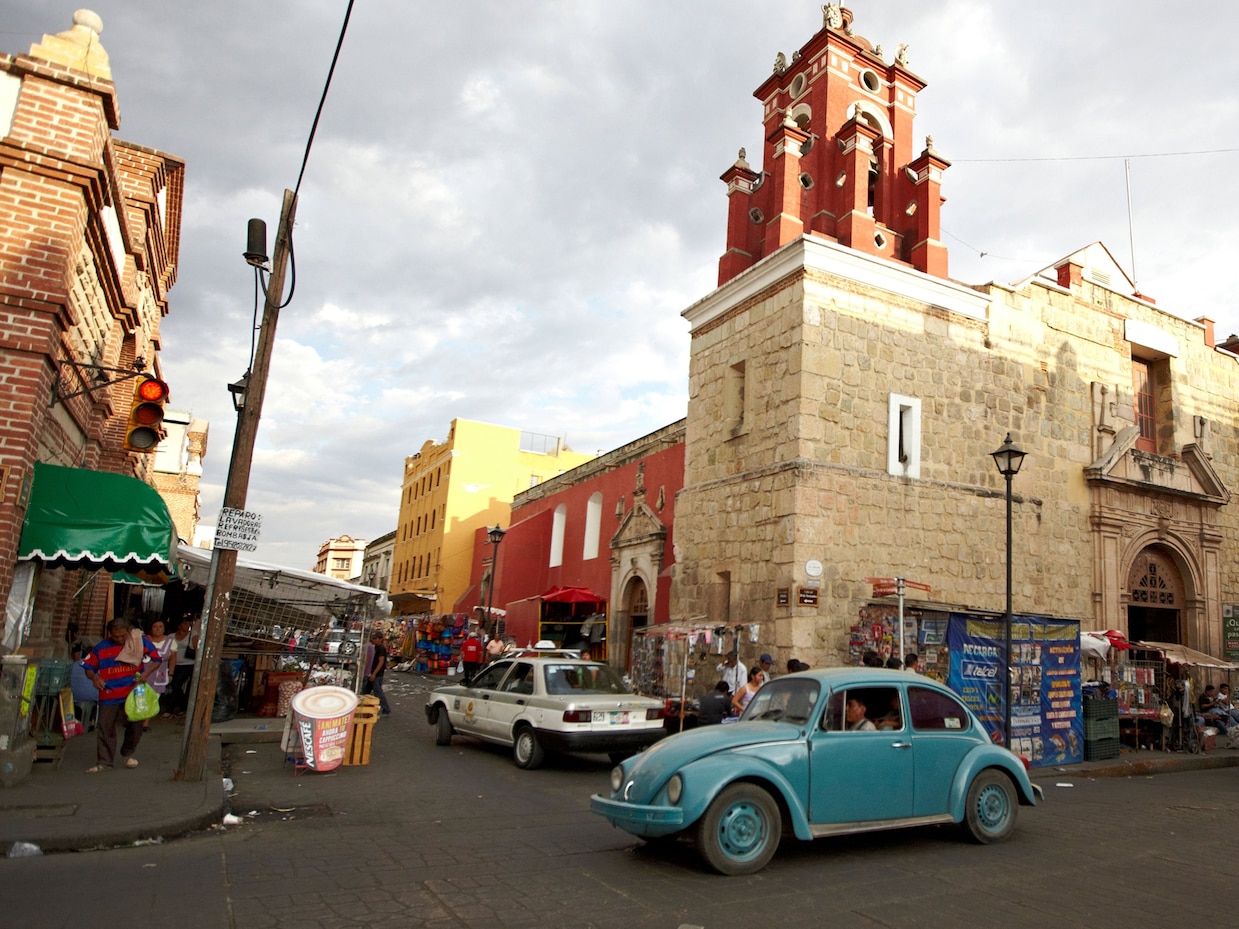 a person driving a blue car on a street in Mexico