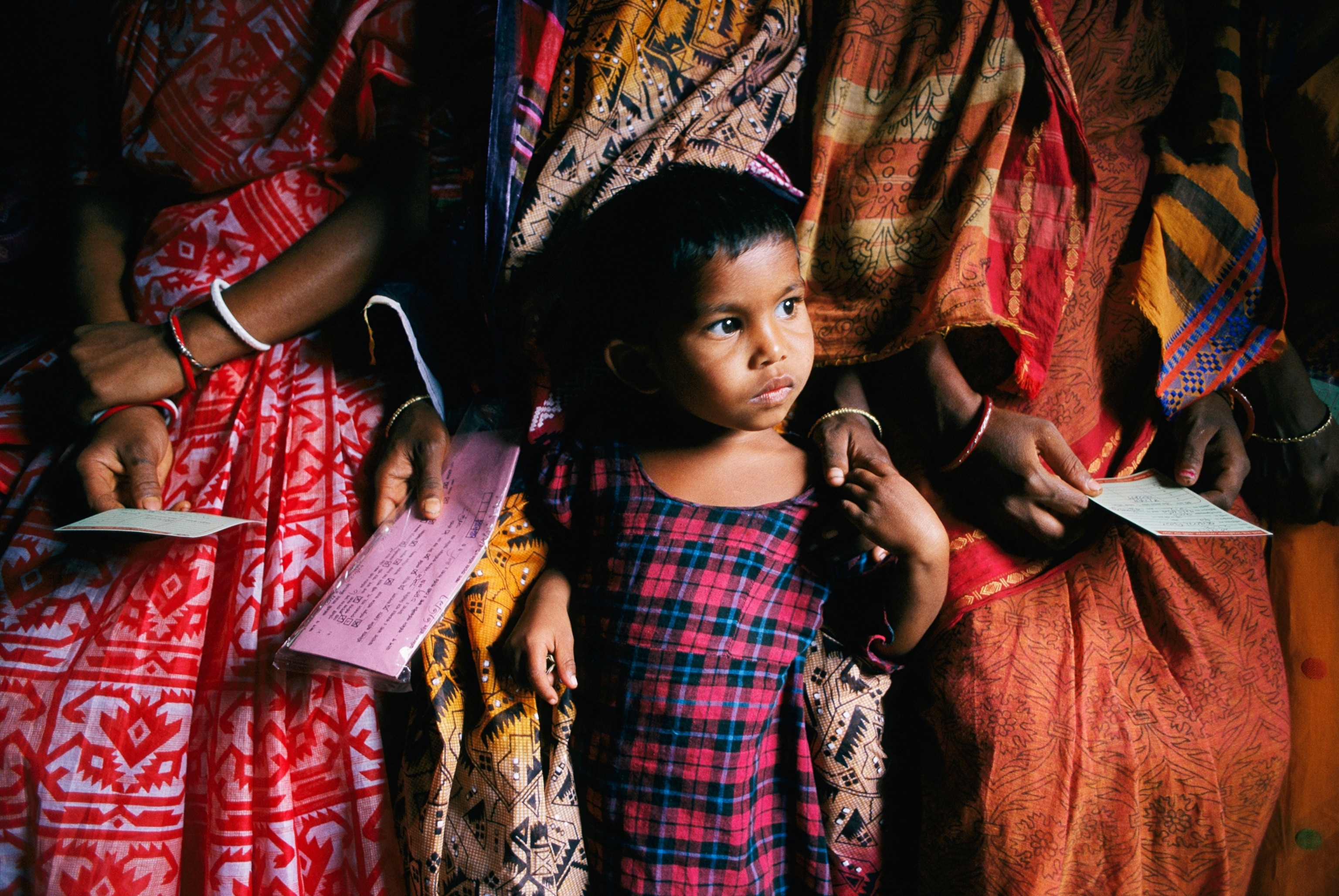 Photograph by Child nestled in her mother's sari at a clinic in Bangladesh