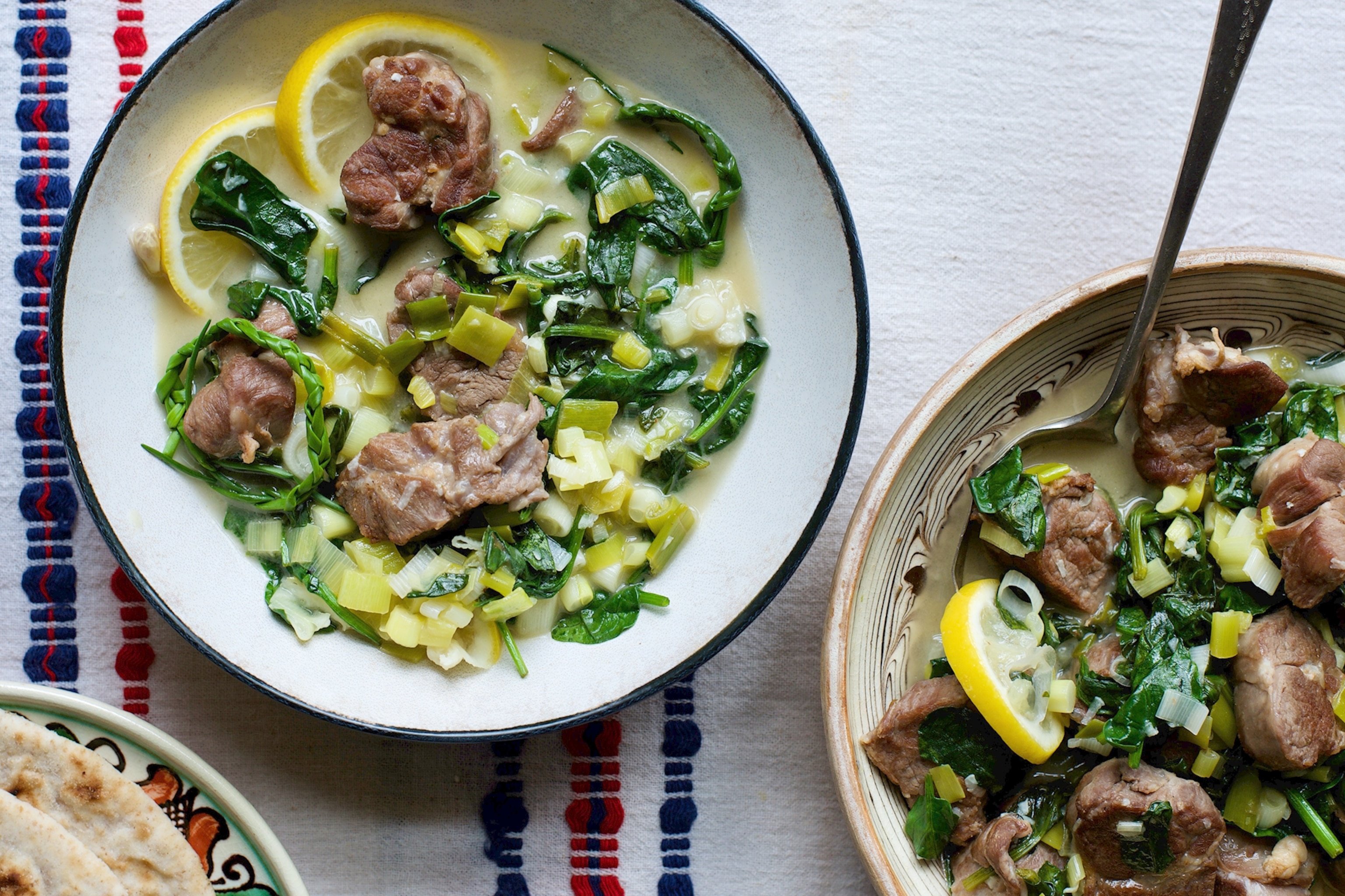 A bowl of stufat, a lamb stew topped with spring onions.