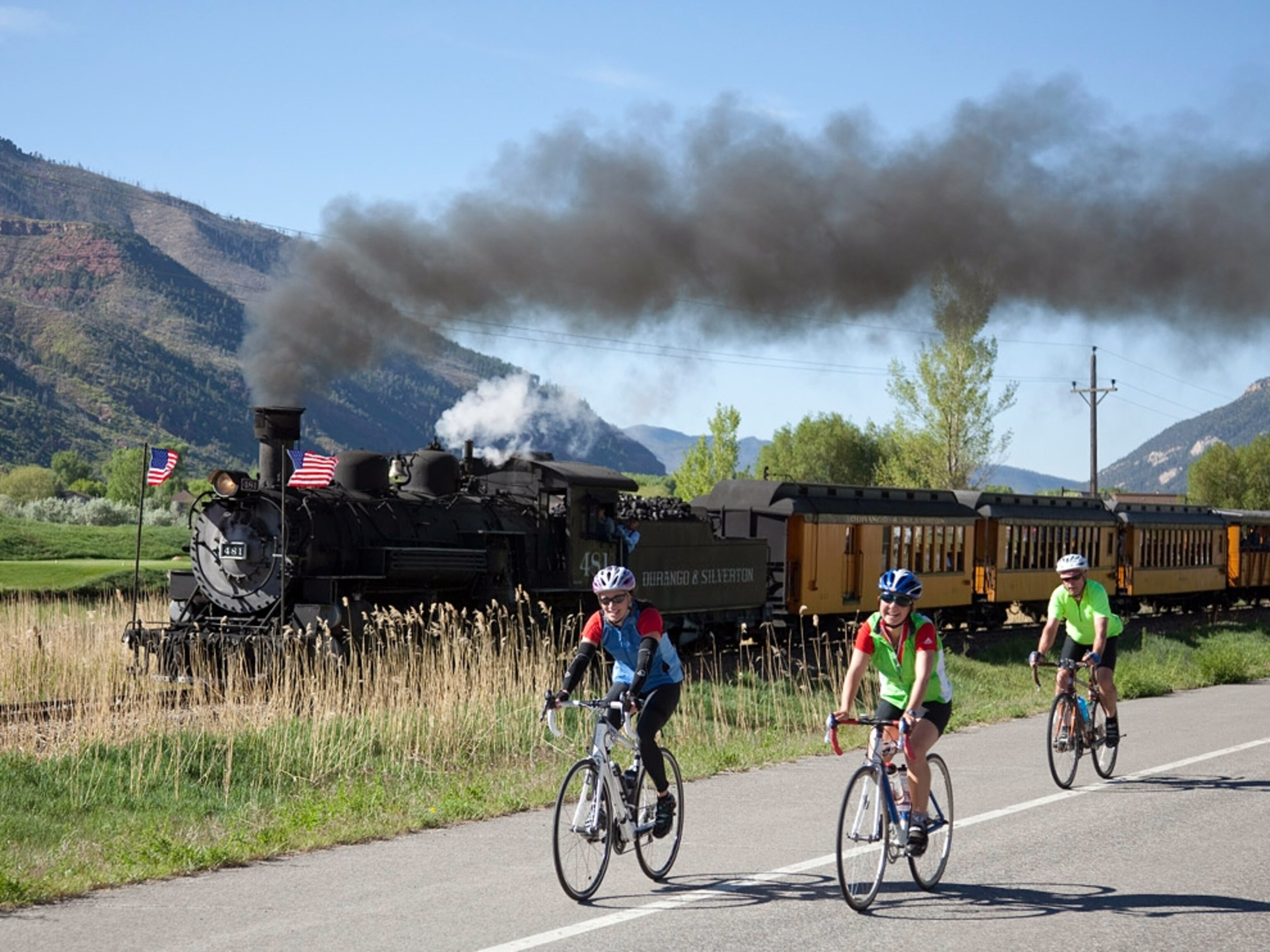 Bikers ride alongside a steam train during the Iron Horse Bicycle Classic.