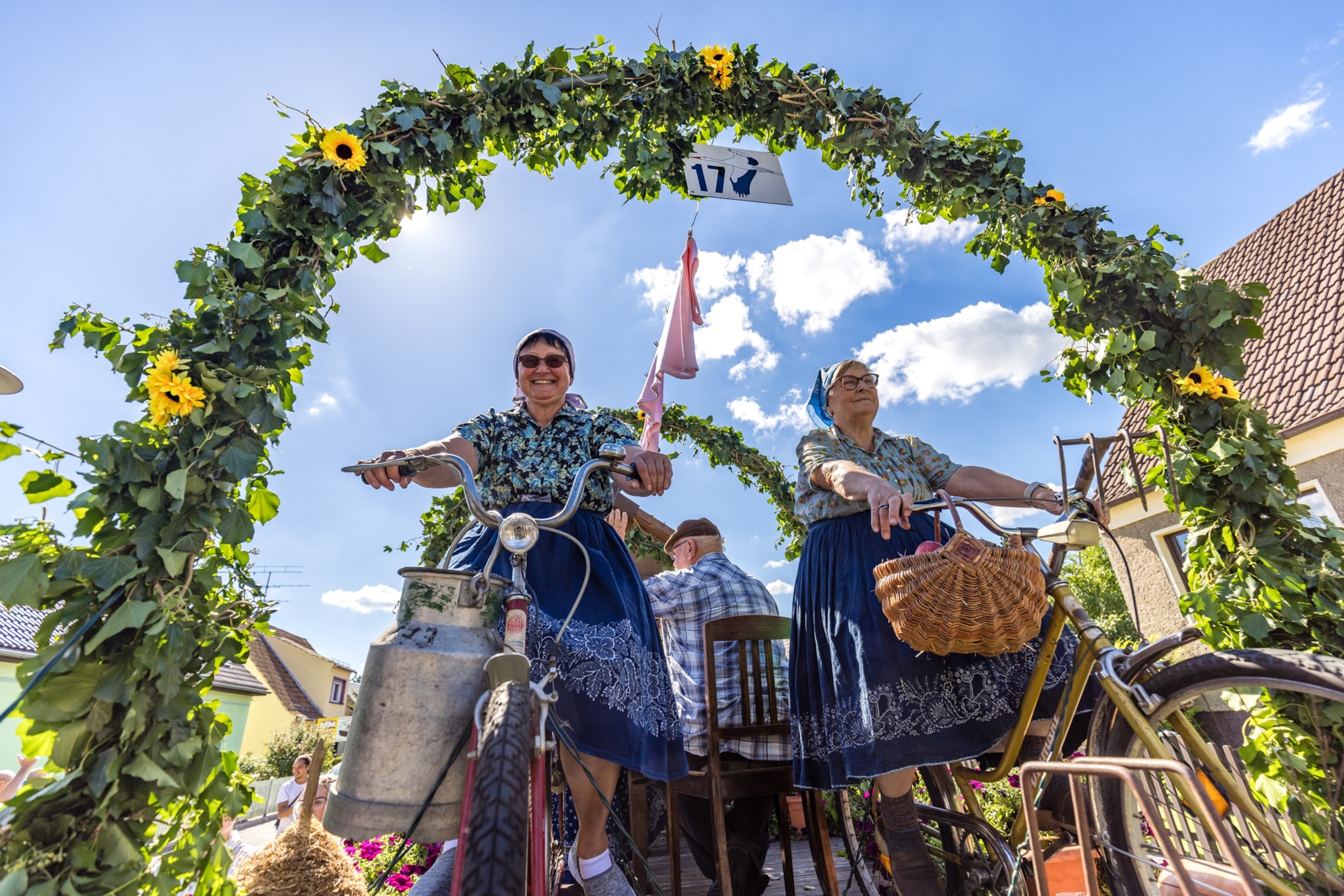 Women dressed in traditional Spreewald costumes take part in the traditional parade through the center of Burg on bicycles as part of the local history and costume festival.