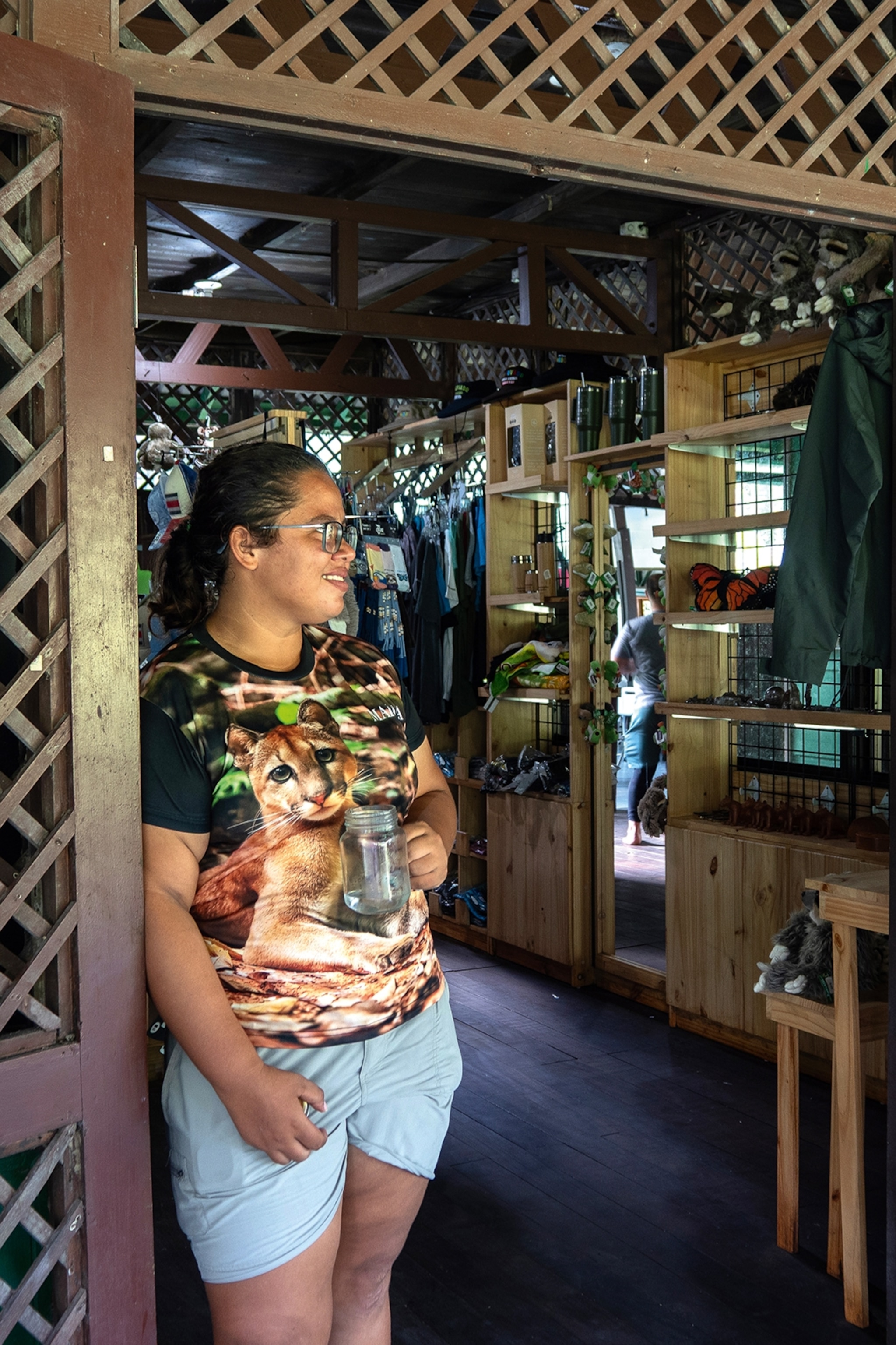 A young woman leaning against a wooden door frame of a ranger station.