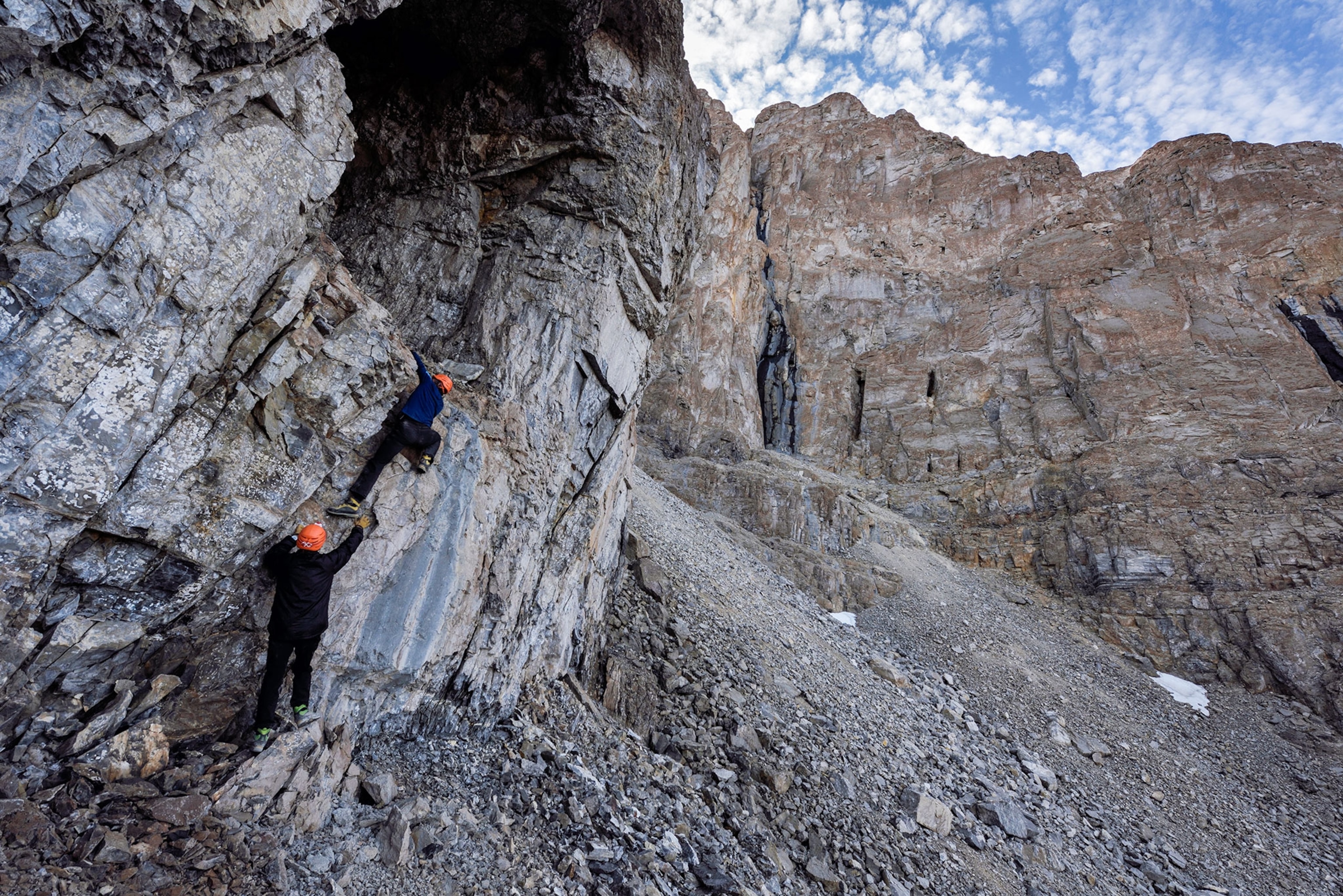 people climbing into a cave