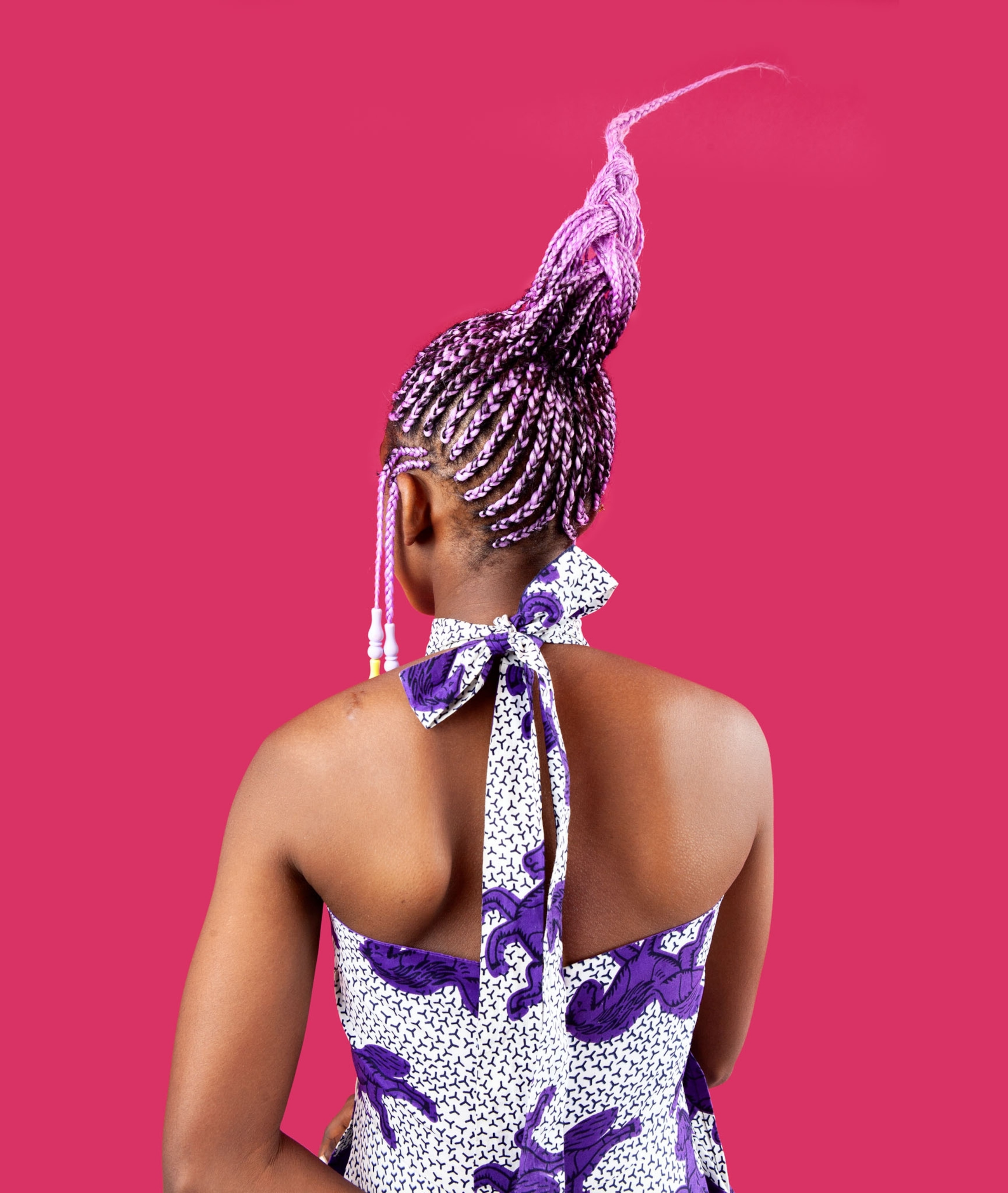 Picture of woman with hairdo designed by sectioning hair with a comb and using lavender hair extensions braided into the woman’s hair. Beads added to side braids.