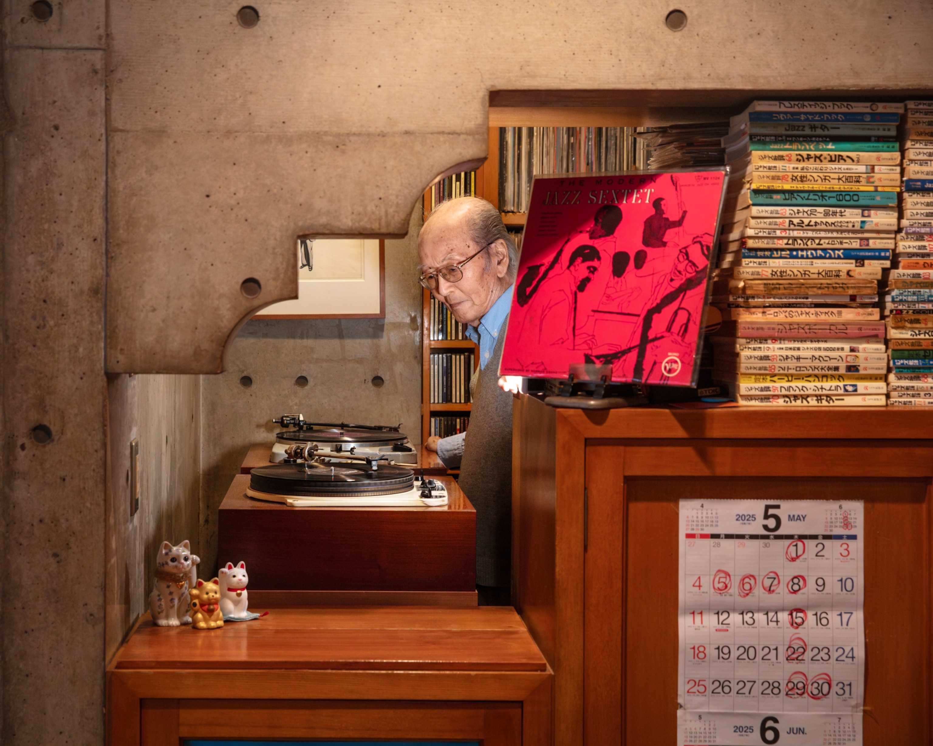 Elderly man in eyeglasses spinning a record.
