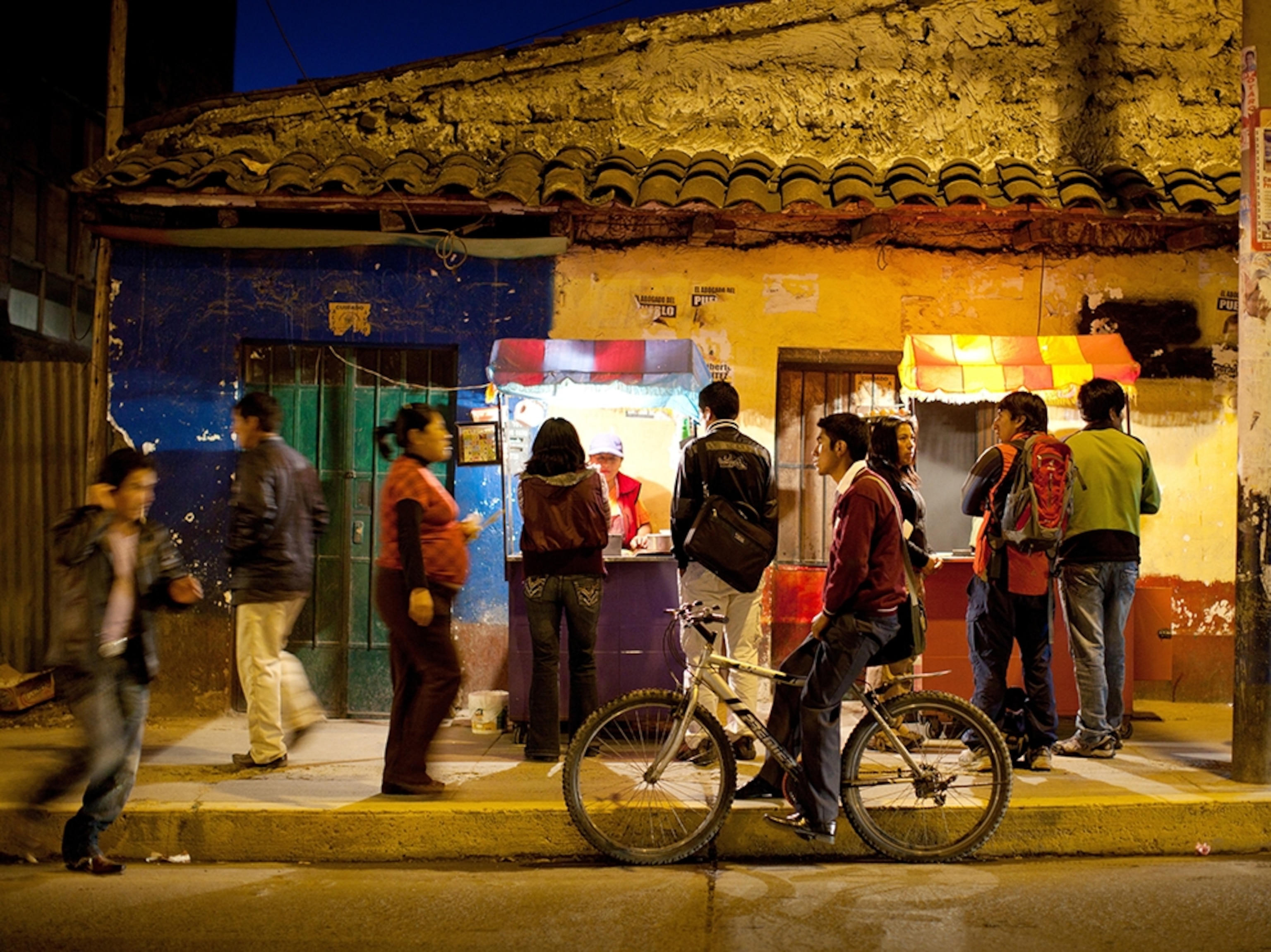 people at a food stall on the street in Peru