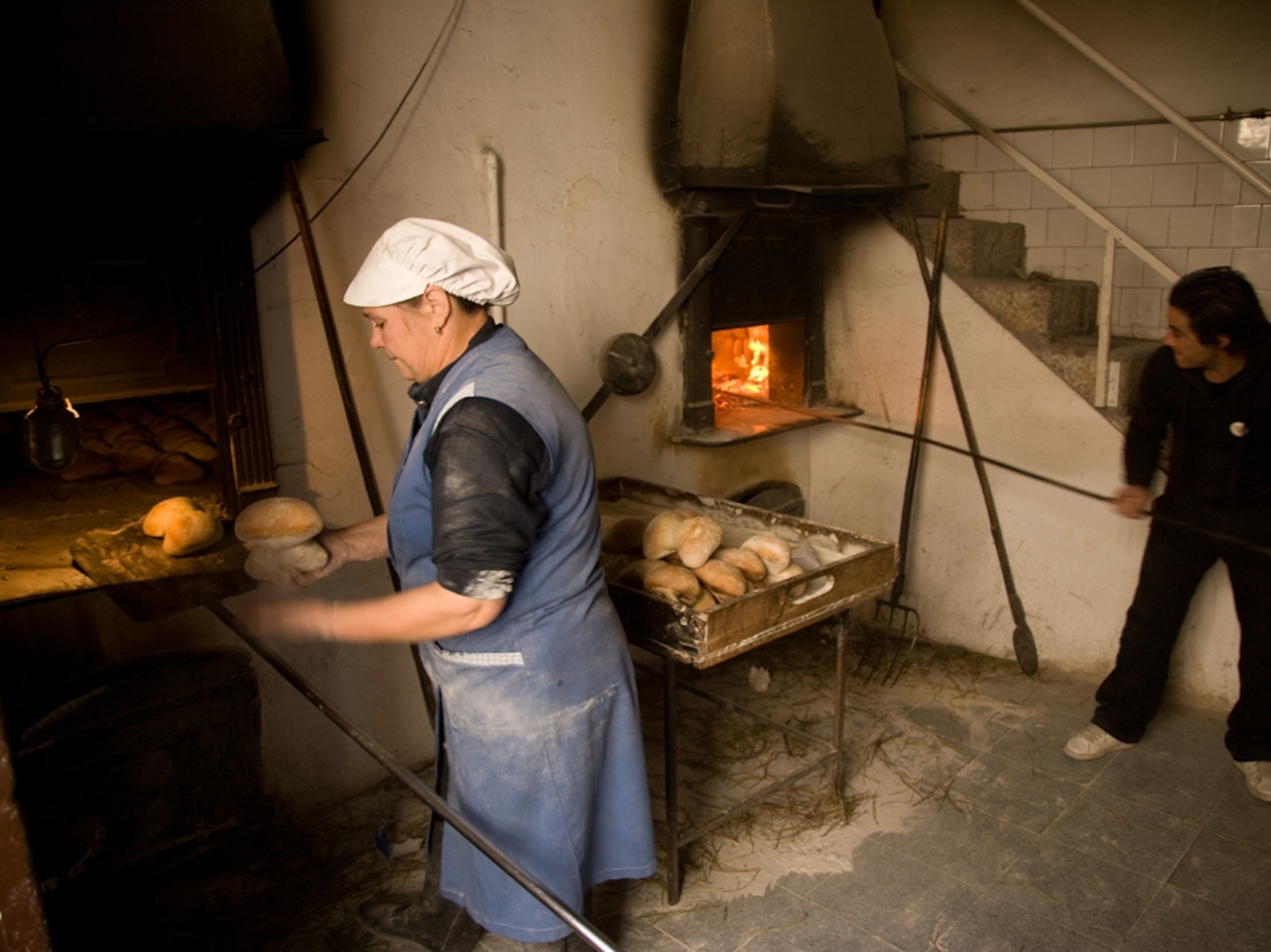 Woman makes bread at Barrigodos bakery, Favaois, Portugal