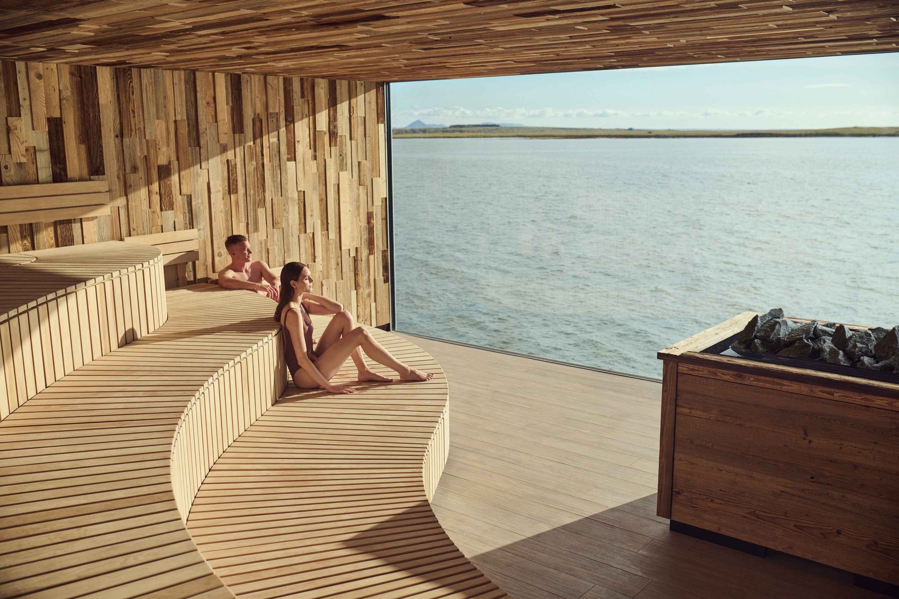 Two people sat in the sauna at  Sky Lagoon geothermal spa 