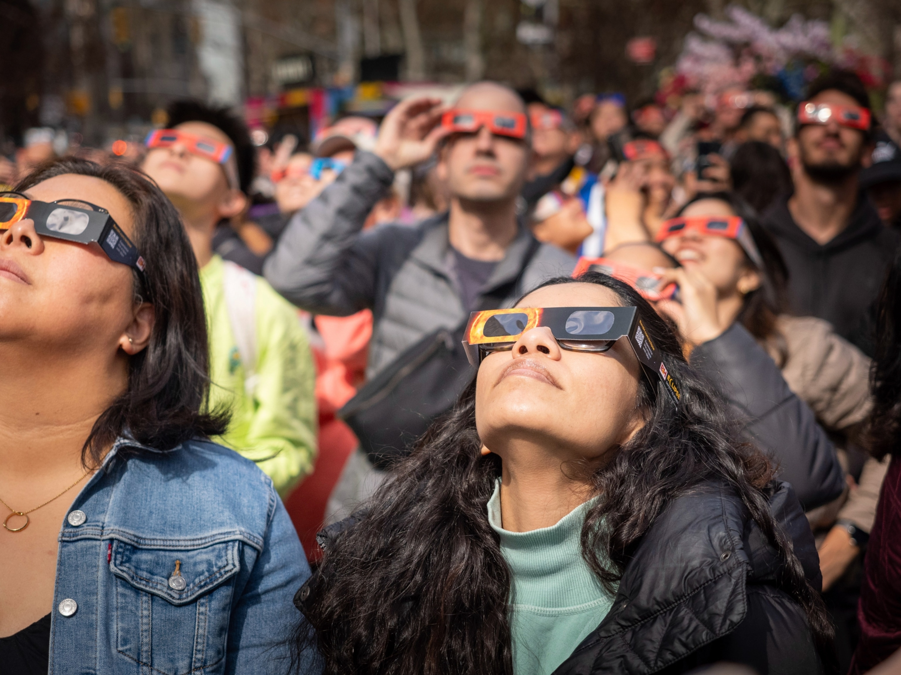 People watch the partial solar eclipse with special eclipse glasses.