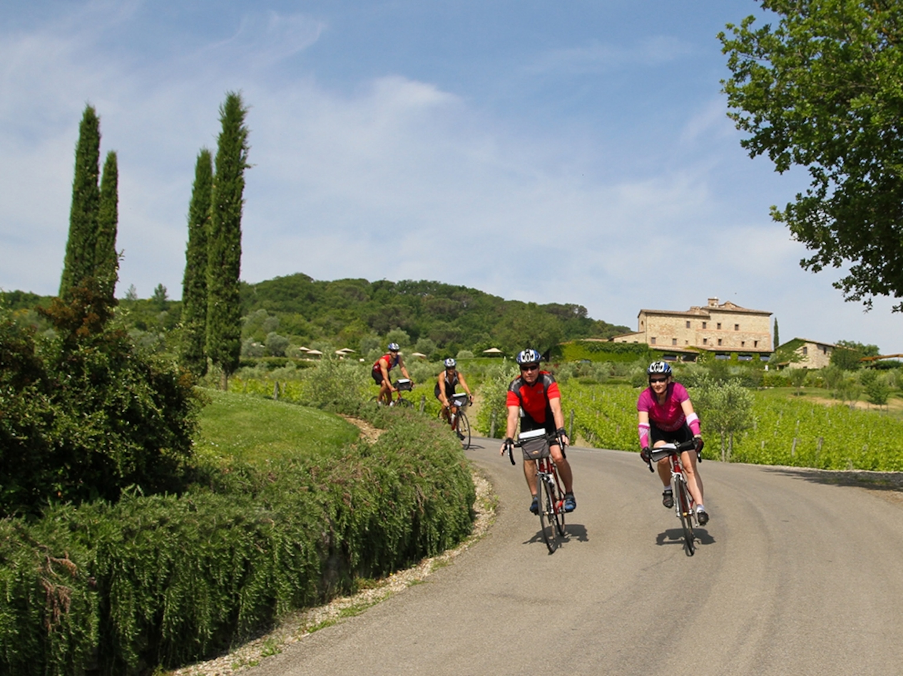 bikers on a curving road in Tuscany