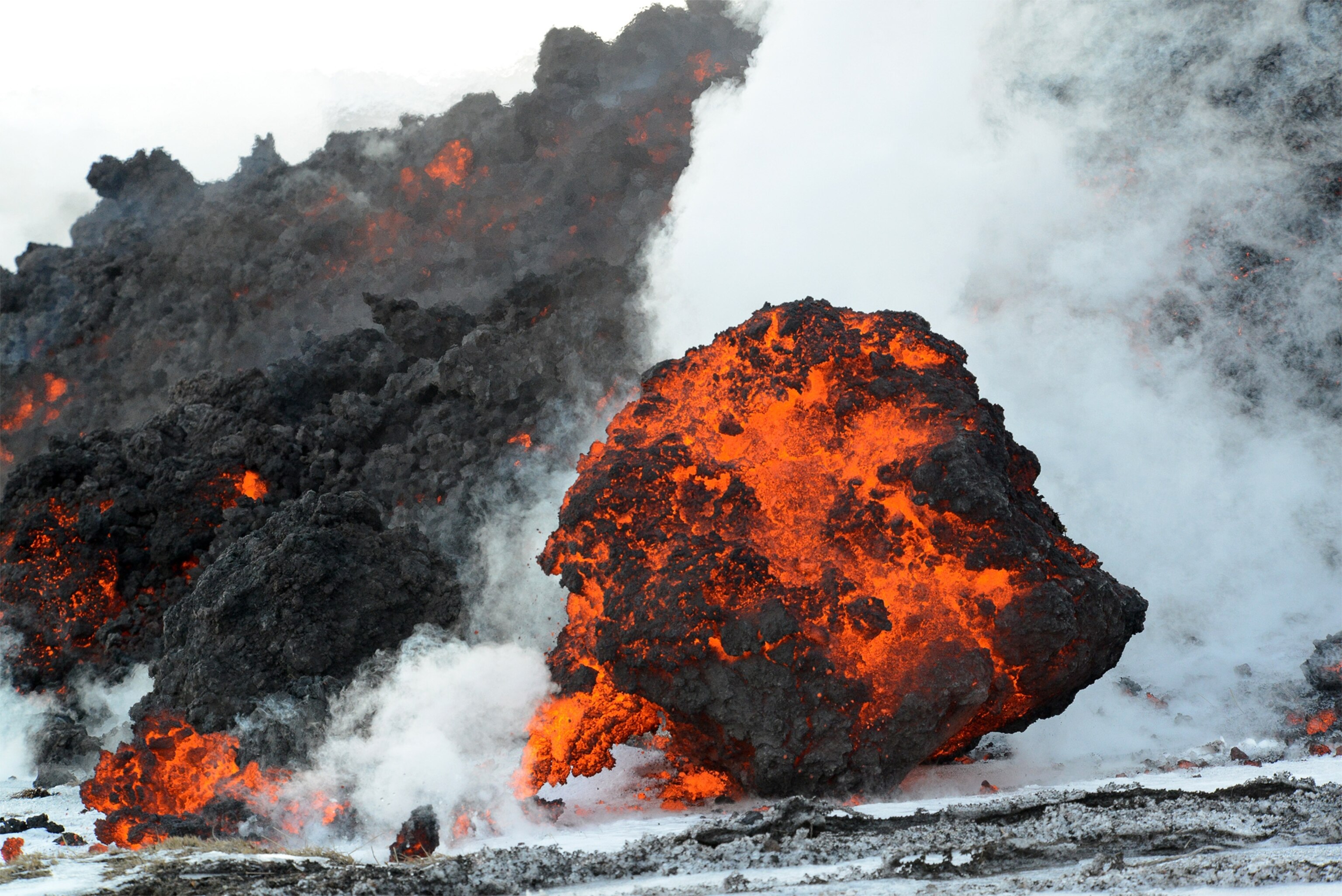 a lava flow rolling forward over snow in Kluchevskoy Nature Park in Kamchatka