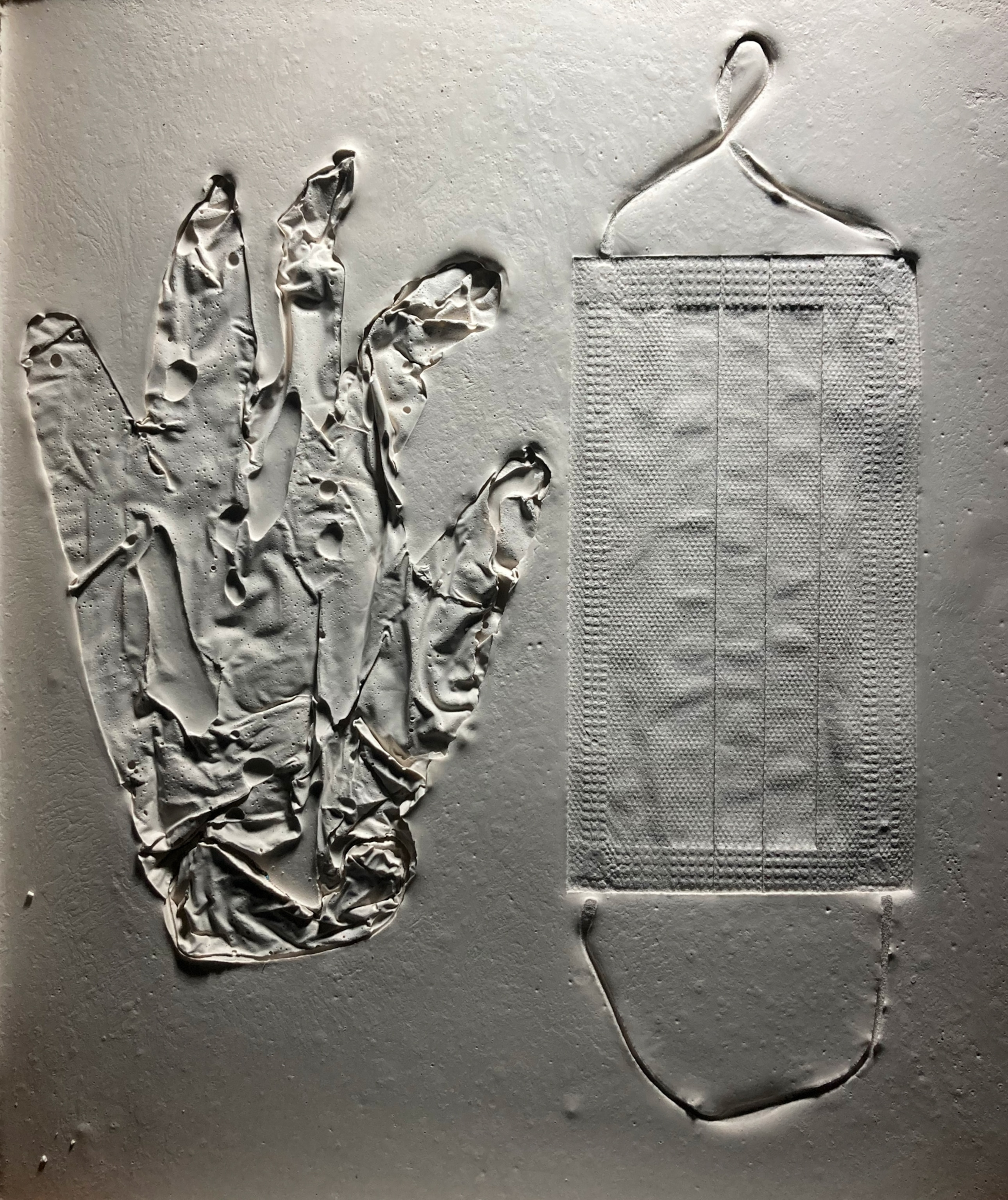 The imprints of a plastic glove and a mask on a mock fossil