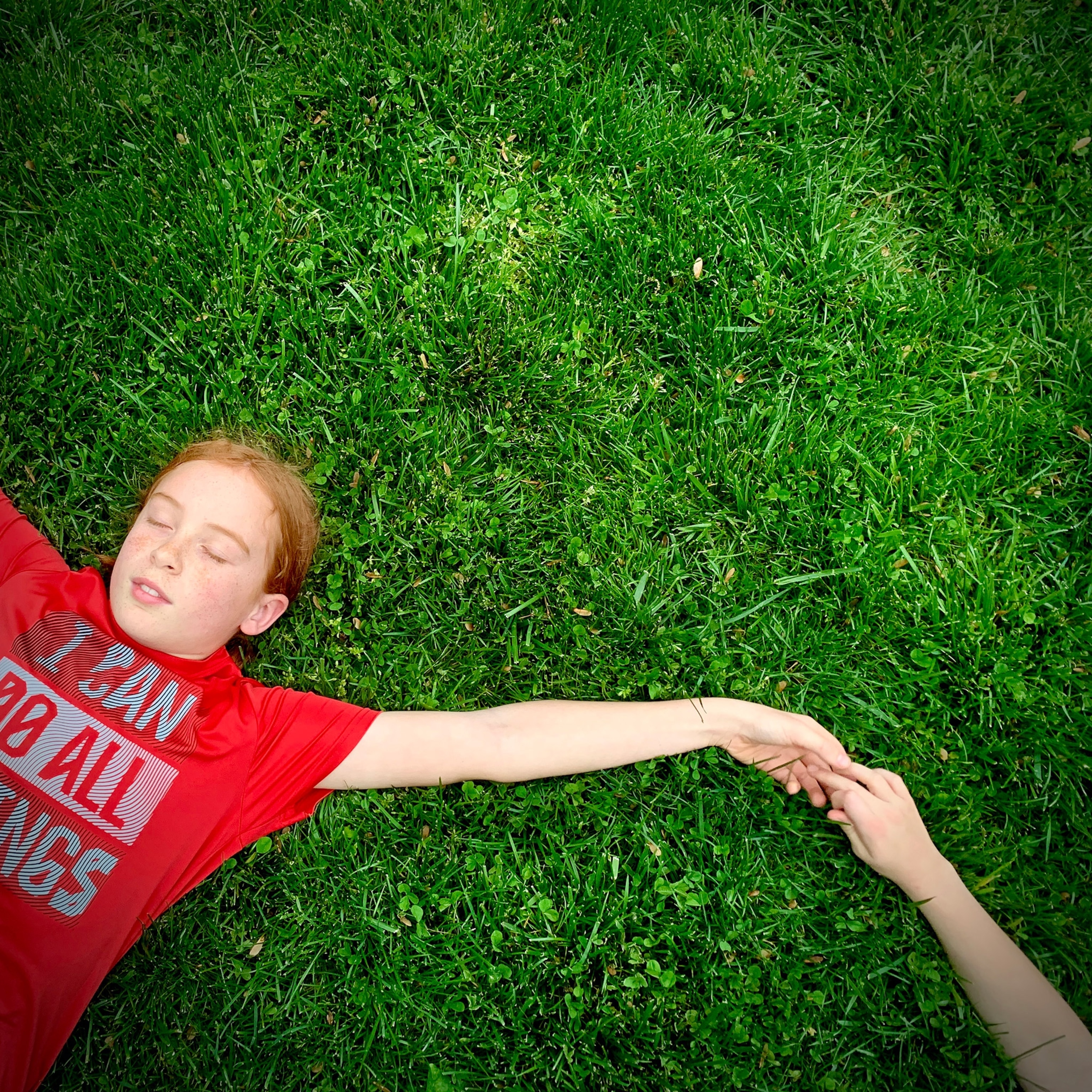 two children laying in the grass