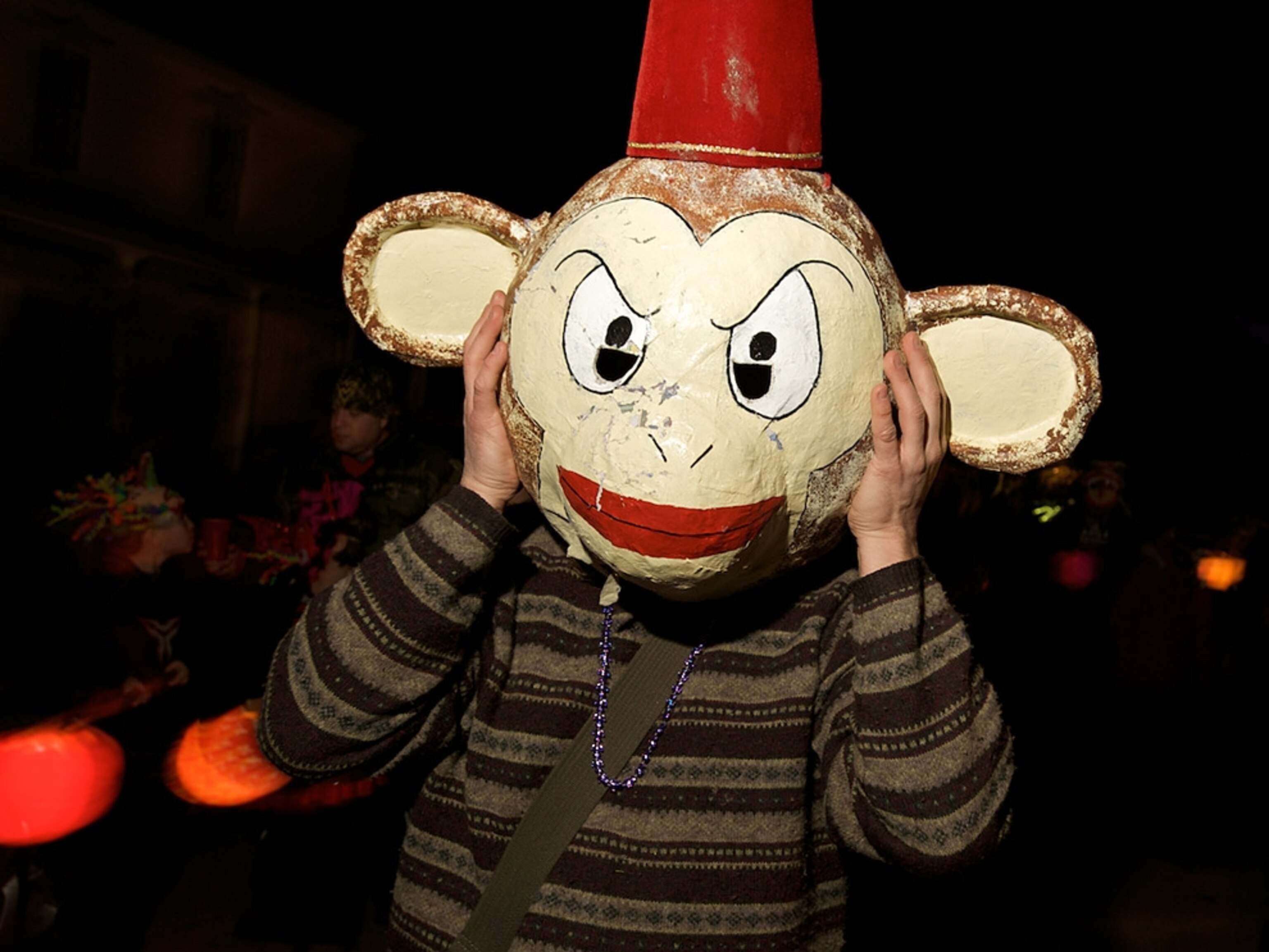 A man wearing a large monkey mask