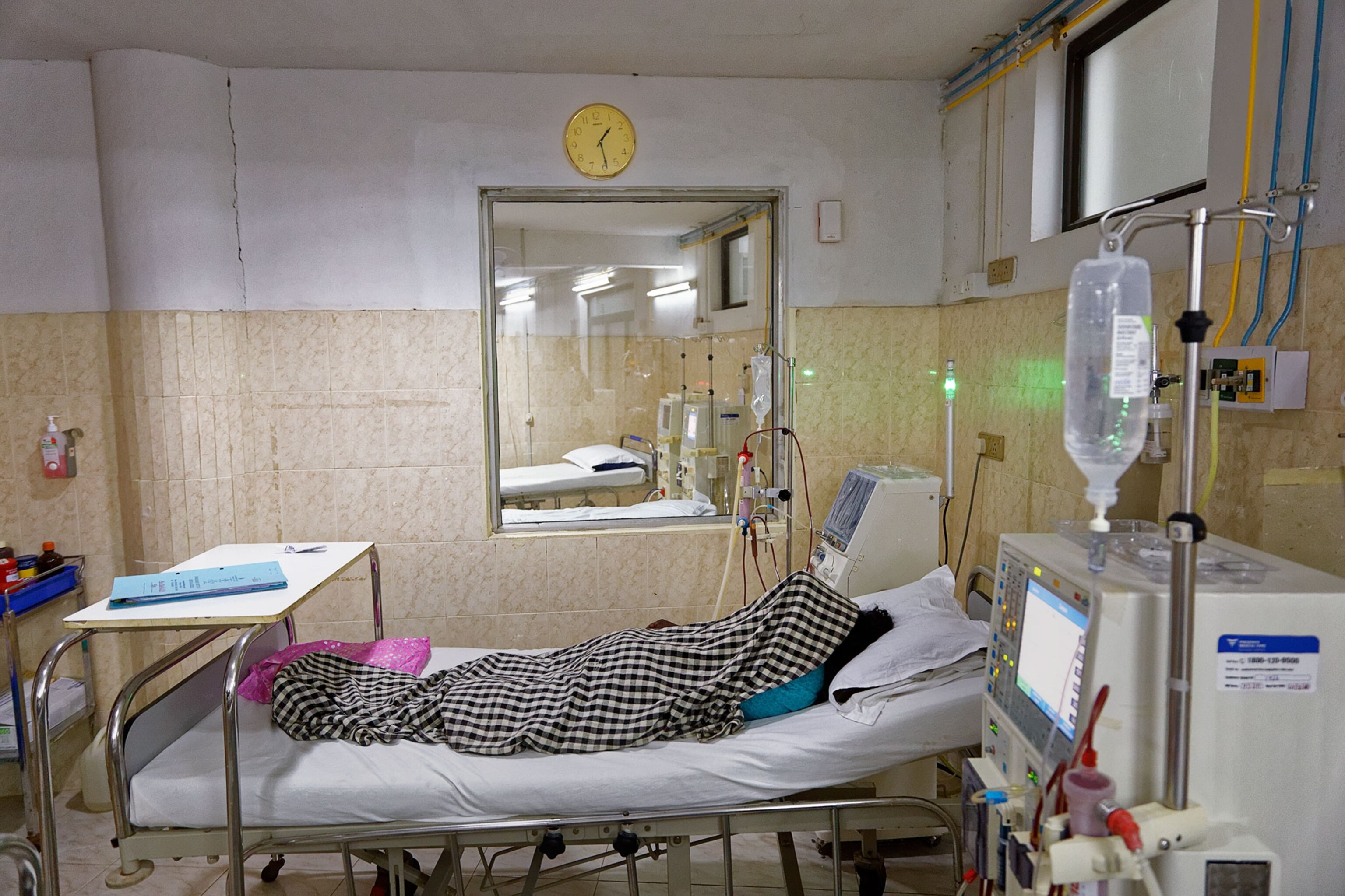 a woman lying under a blanket in a hospital